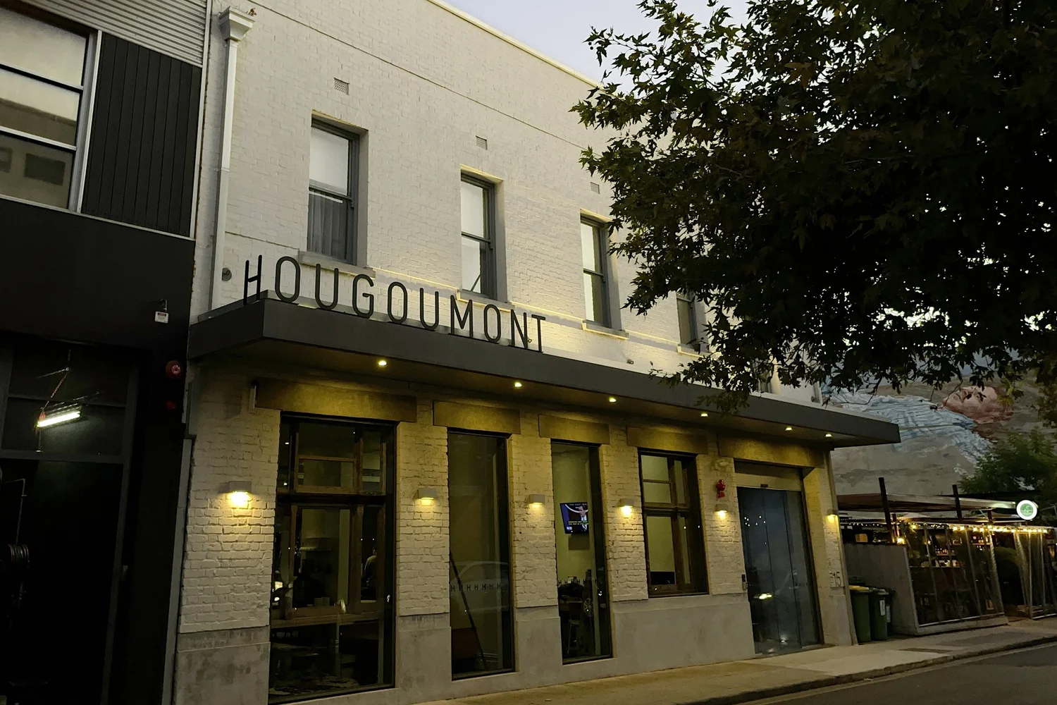 Hougoumont Hotel street entrance beneath the illuminated hotel sign