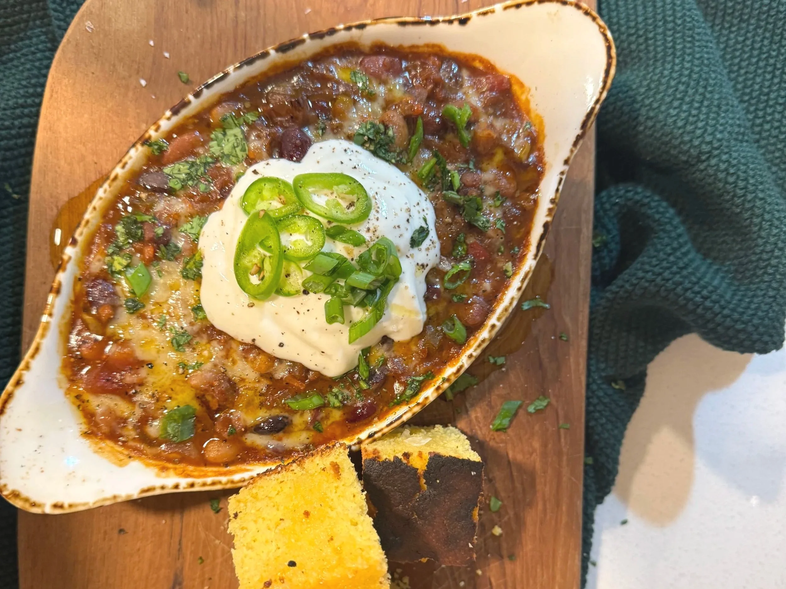 a serving of smoky, spiced bean chili with zesty whipped yogurt and fresh herbs