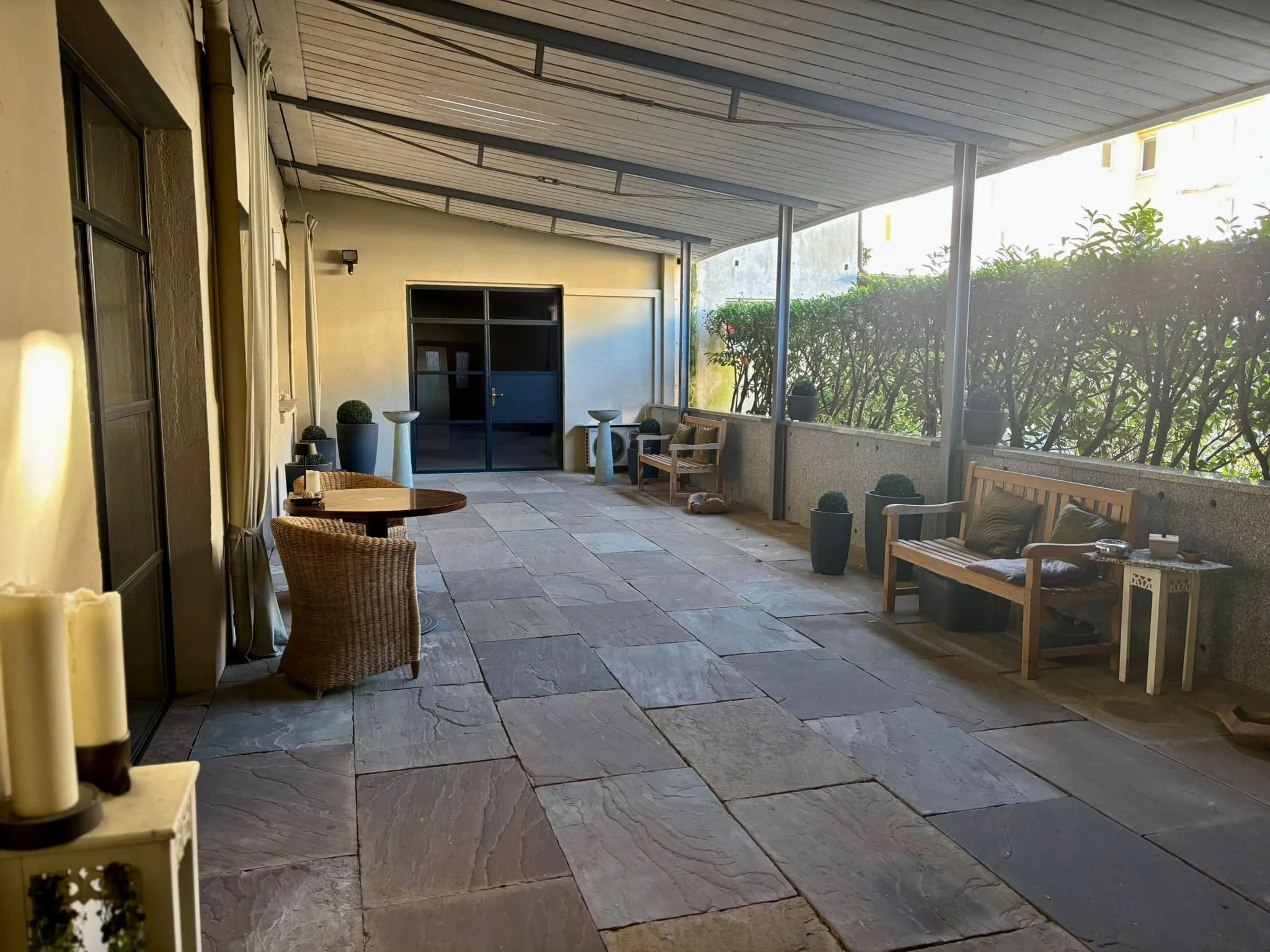 Balkon mit Sitzecke, Pflanzen und Sonnenschein.