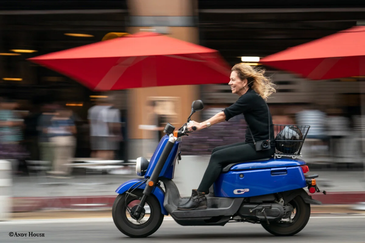 Photographer Andy House captures a shot of Julia Dean riding her beloved motor scooter in front of the Grand Central Market in downtown Los Angeles in 2019.