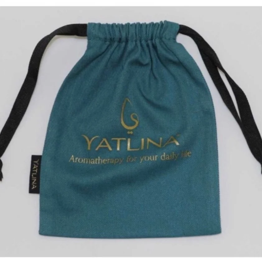 Teal drawstring bag with gold YatLINA logo and the text "Aromatherapy for your daily life" on it.