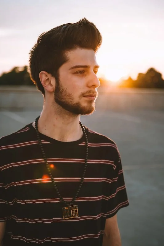 A young man with the sun over his shoulder