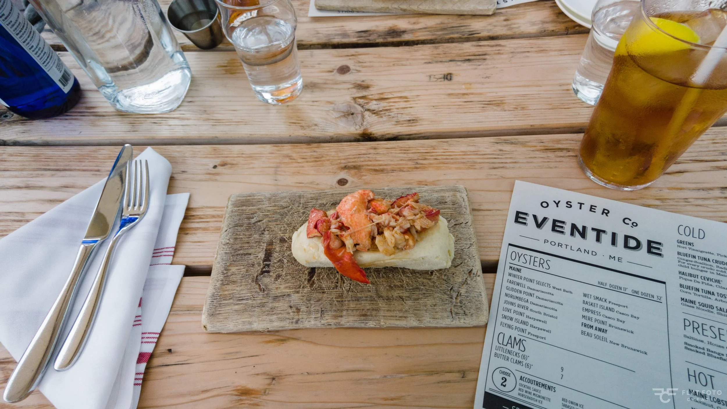An image of a Brown Butter Lobster Roll and an iced tea from Eventide Oyster Co in Portland Maine