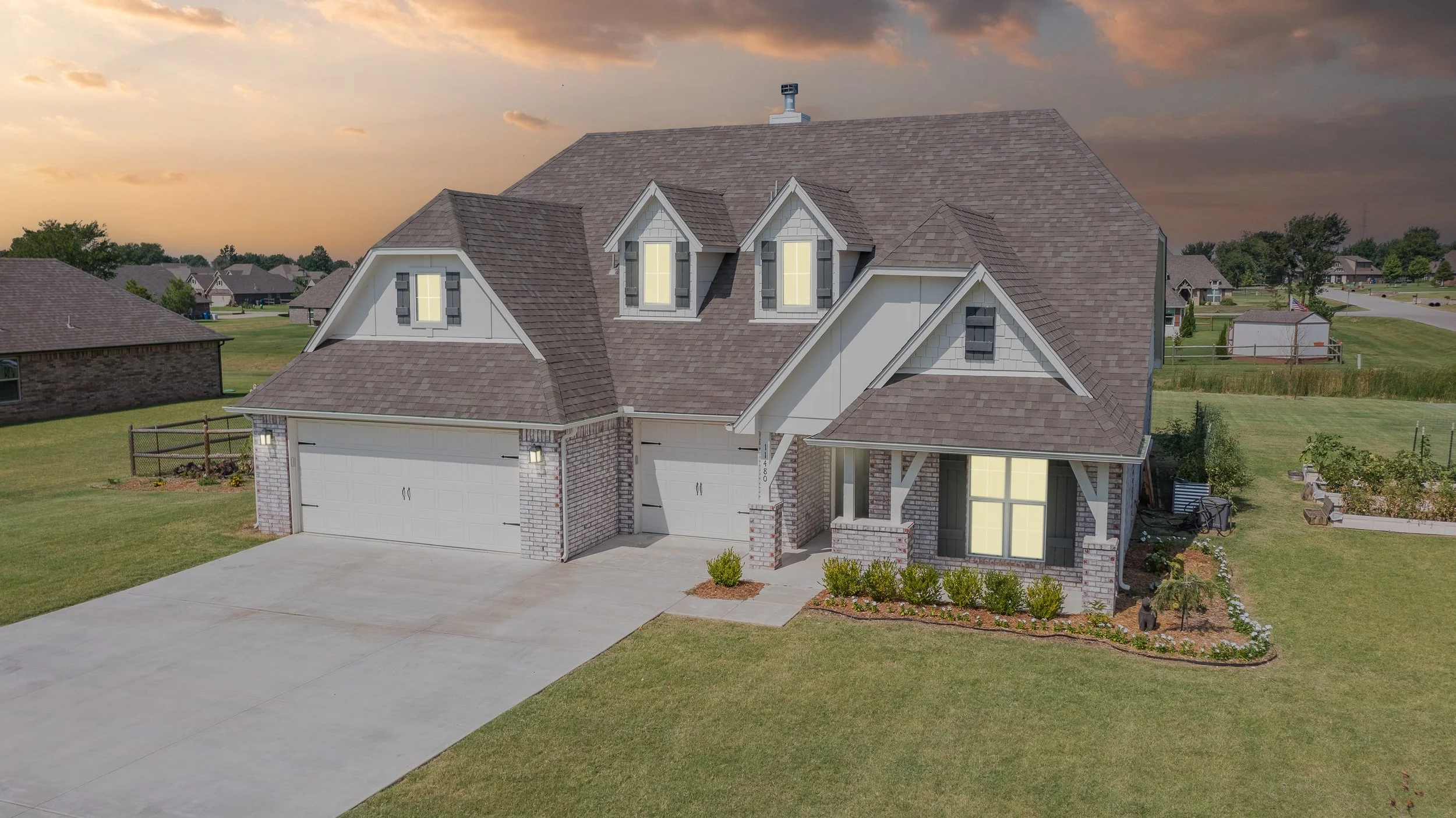 Aerial drone photo of a 2 story white ranch style home during sunset