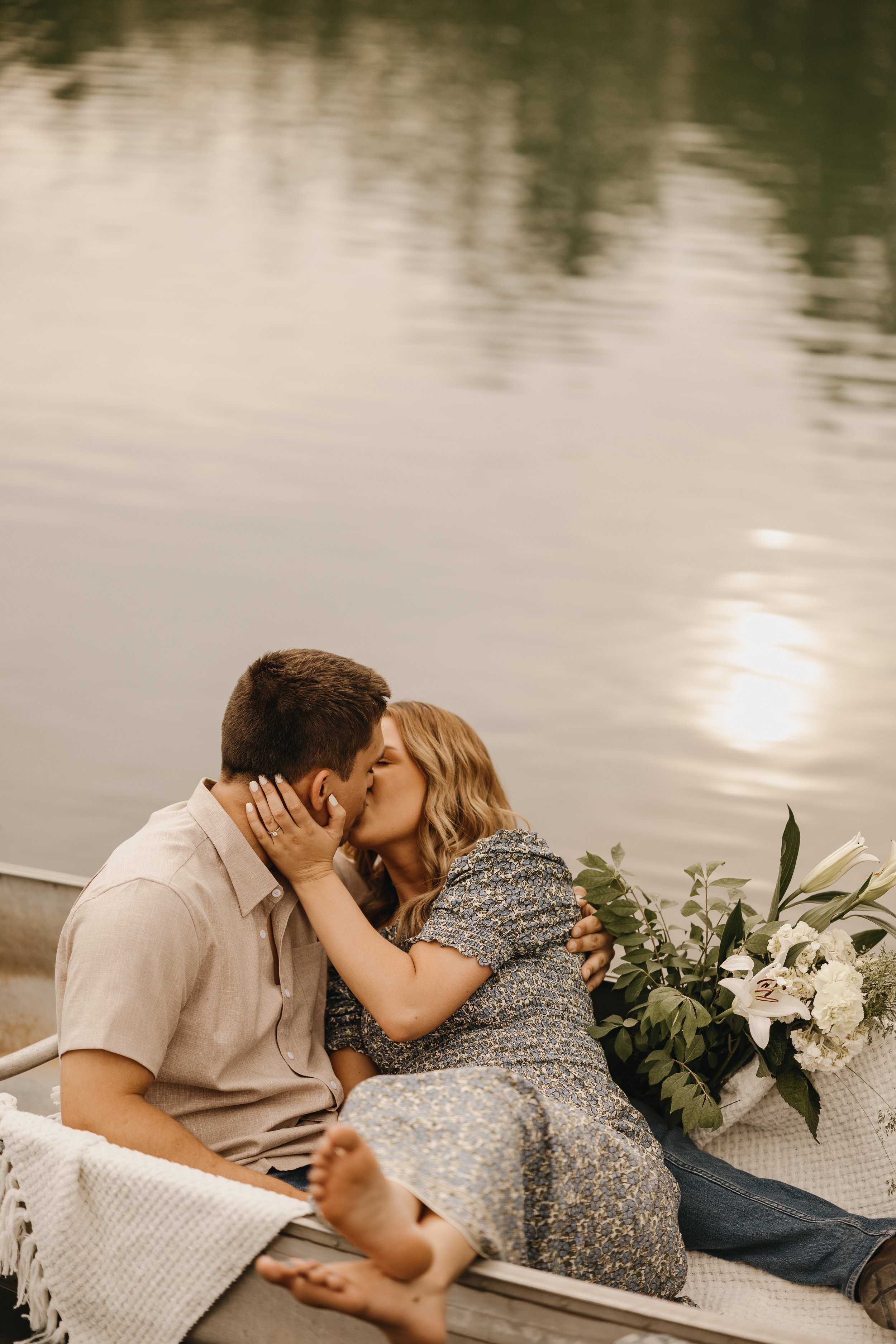 engagement photography session in Anderson Indiana couple sharing a kiss in a canoe summer photography session