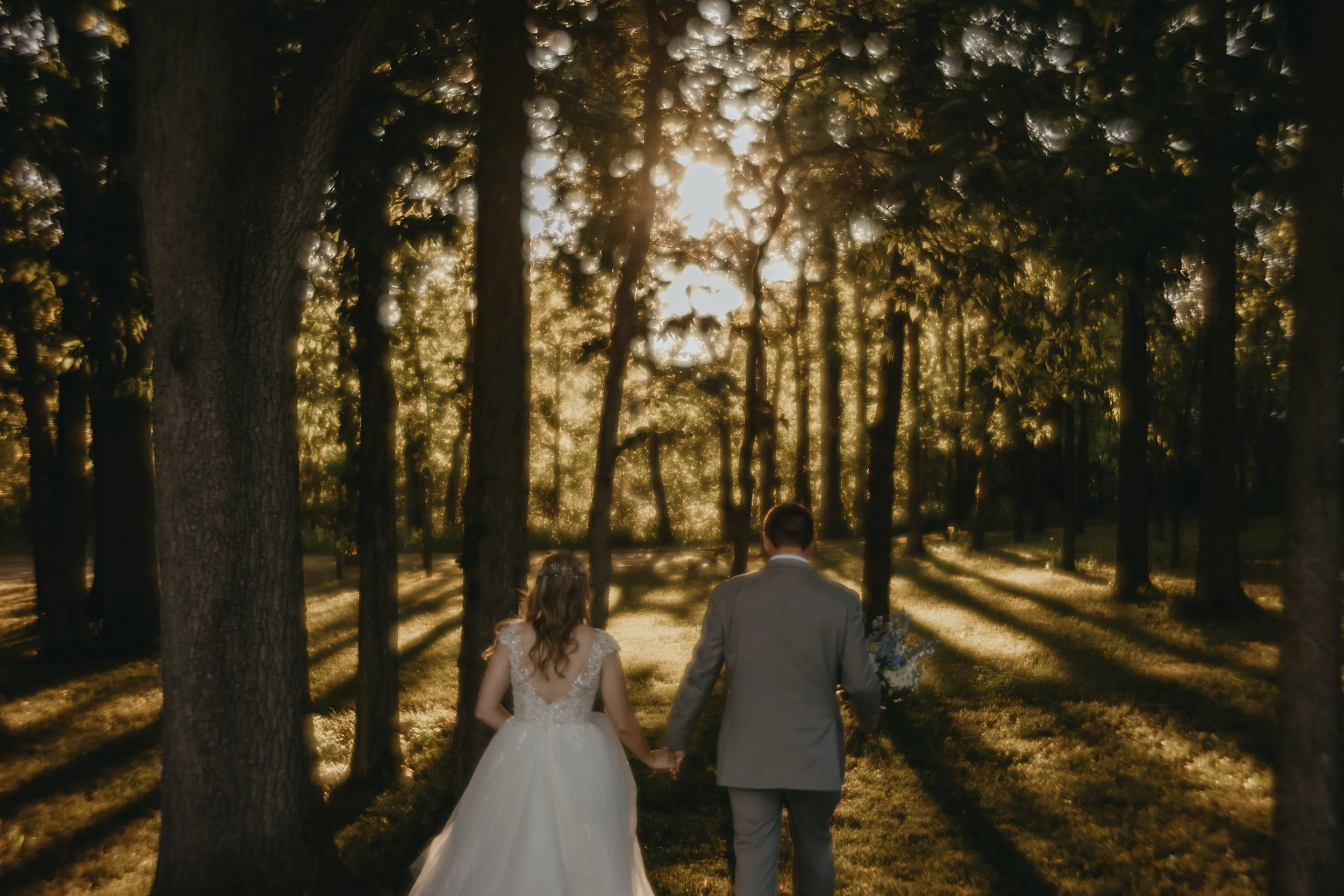 Bride and Groom walking towards the sunset in the forest at The Loft on Isanogle in Muncie, Indiana by Dunckel Haus Photography