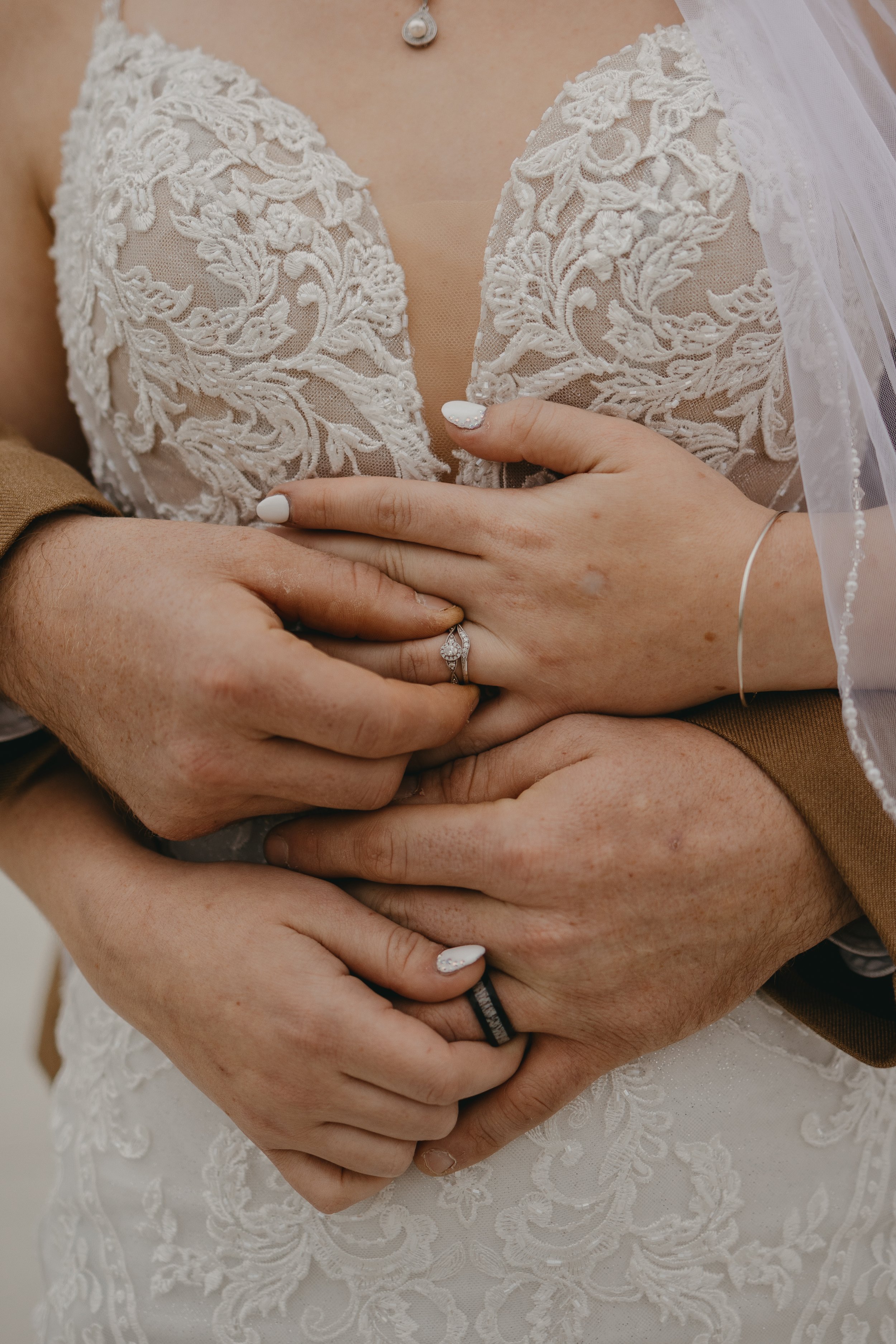 wedding photograph of a bride and groom and their wedding rings on their wedding day near Muncie Indiana
