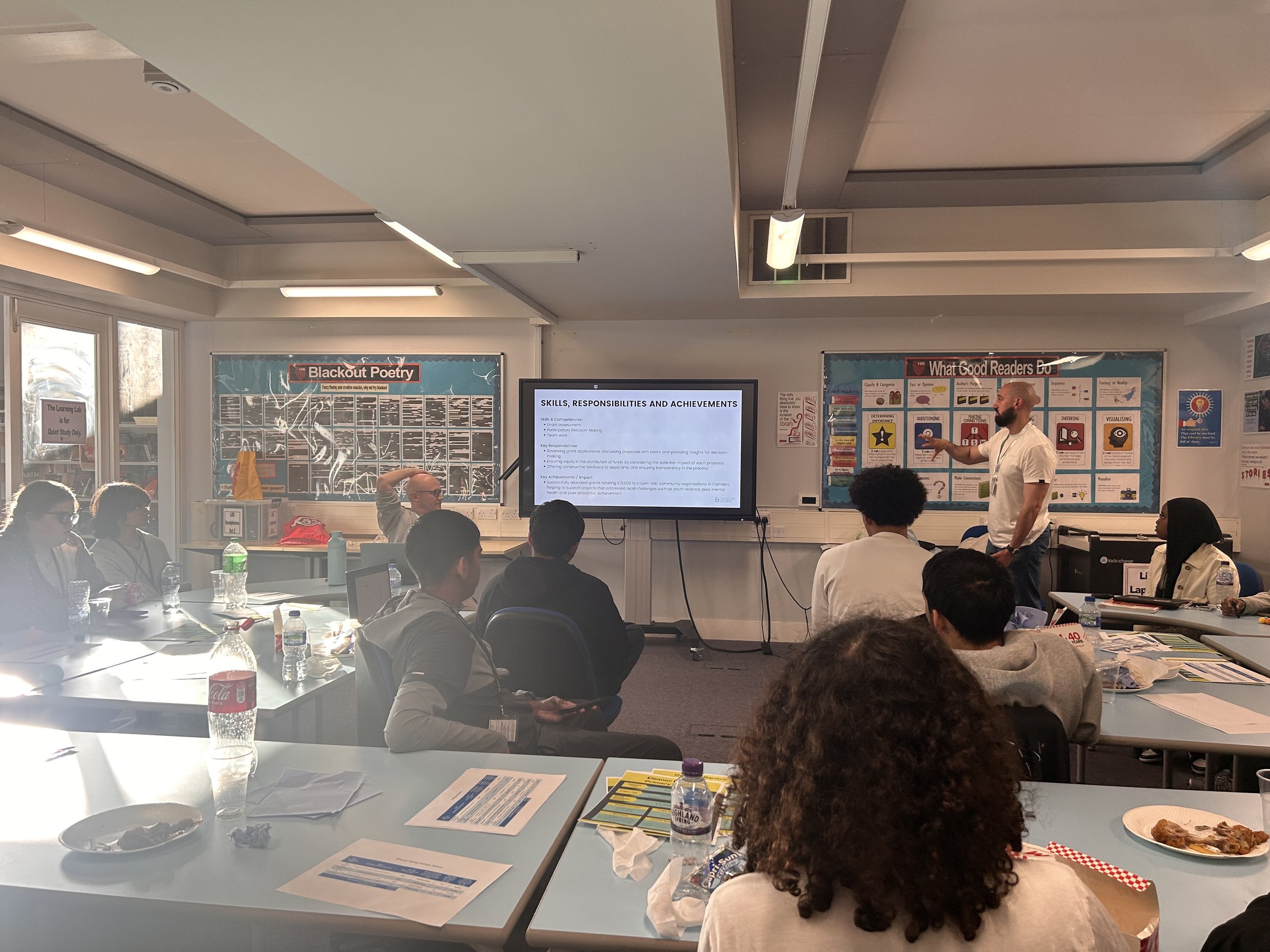 A facilitator presents a grantmaking workshop to a group of young people in a classroom.