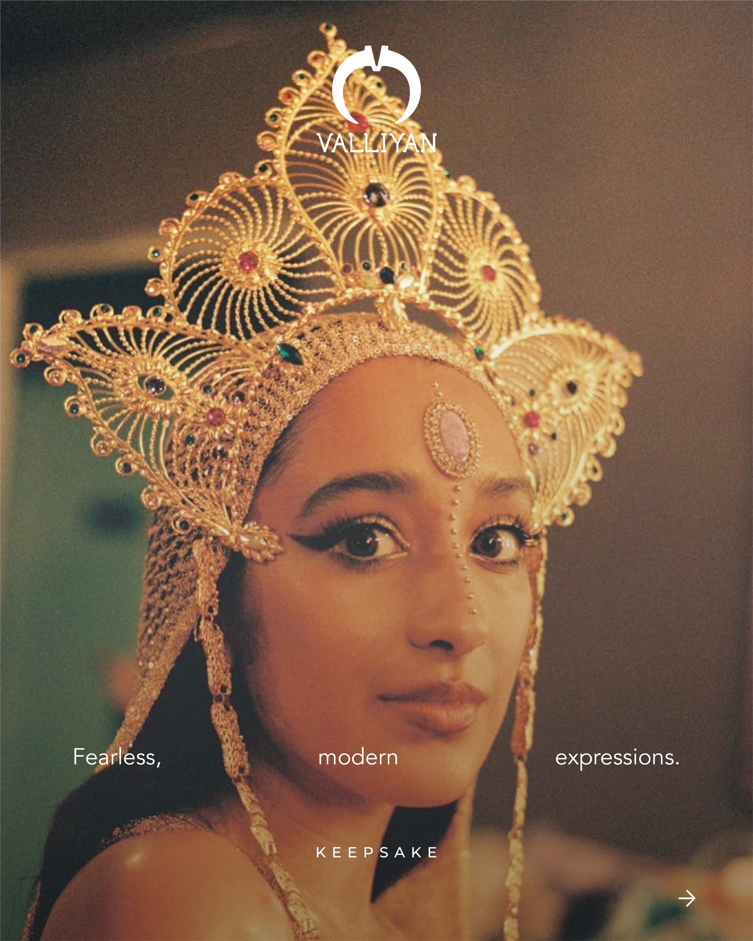 A woman adorned in gold jewelry and an ornate gold crown, with intricate makeup, looking confidently at the camera.