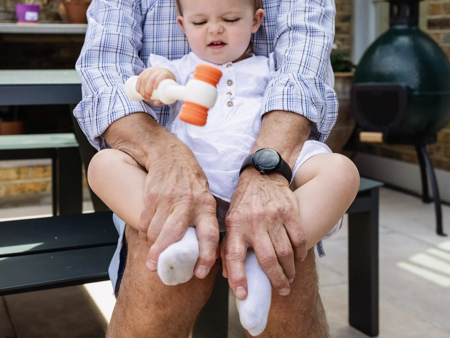 grandpas hand holding baby on lap