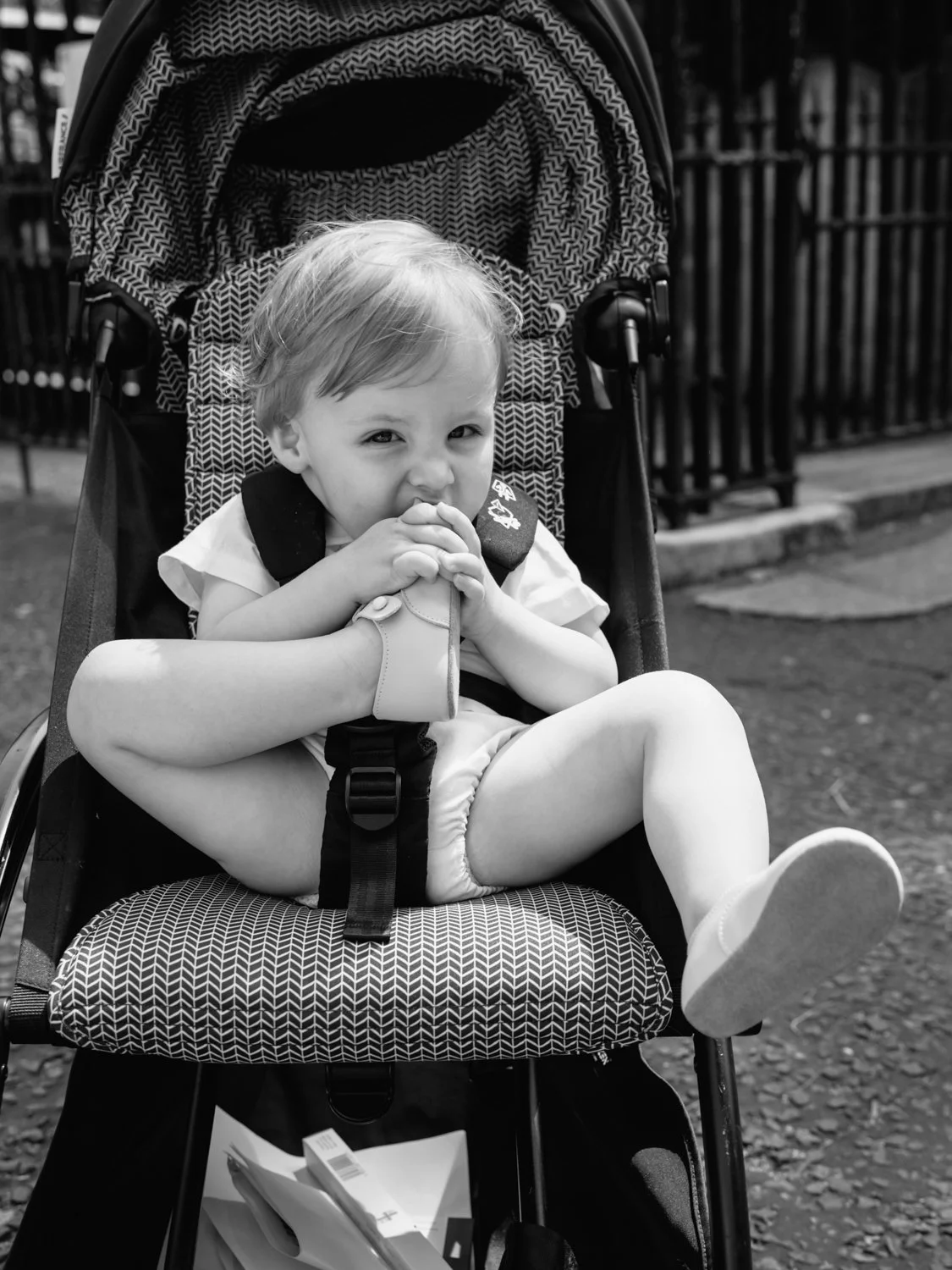 Baby chewing his feet in pram