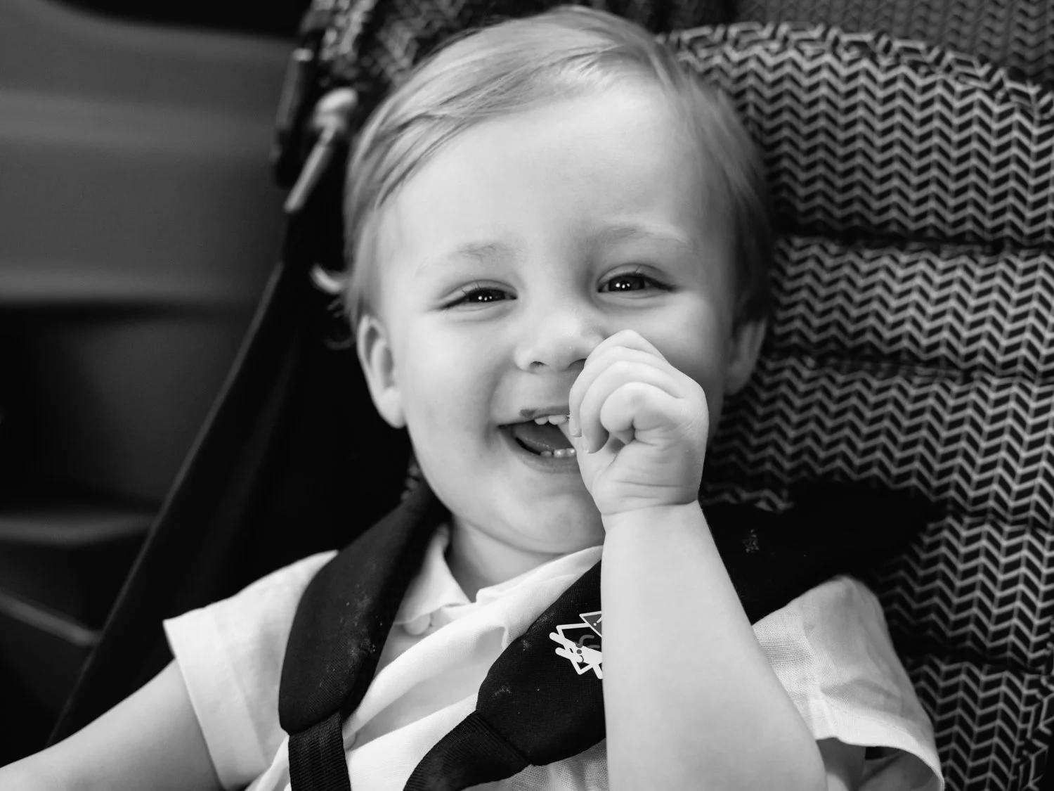 Baby smiling right at me with thumb in his mouth from his pram
