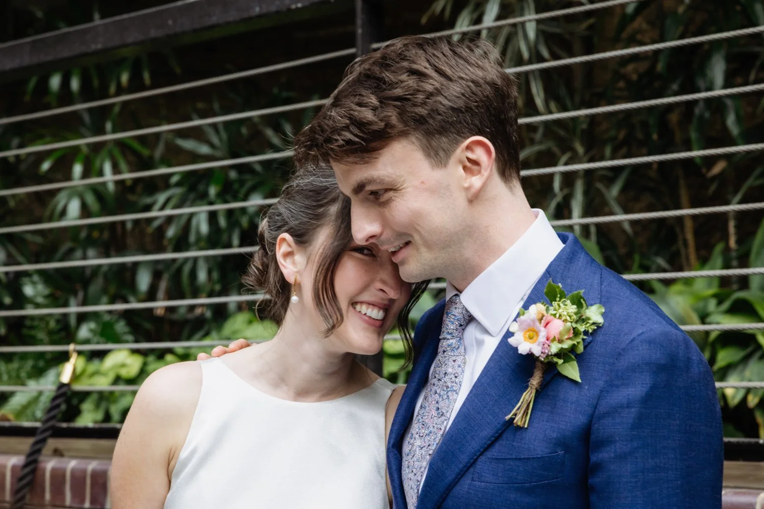 Bride peering at us as she hugs the groom.