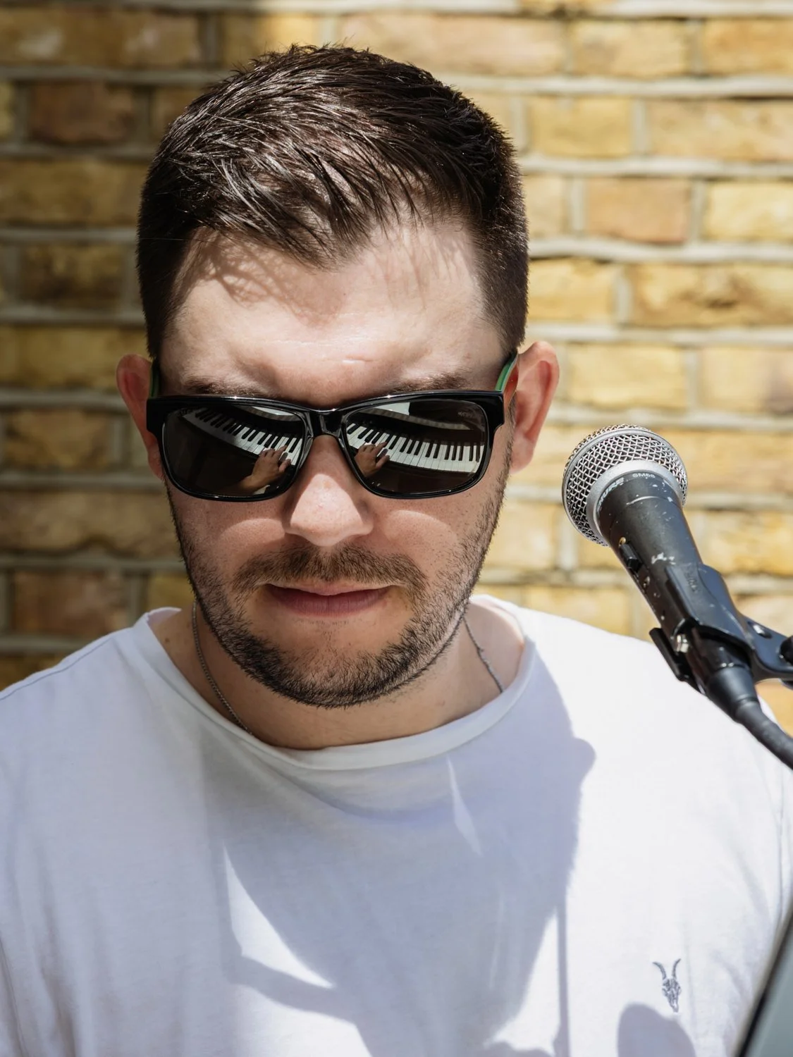 piano man with piano reflected in sunglasses