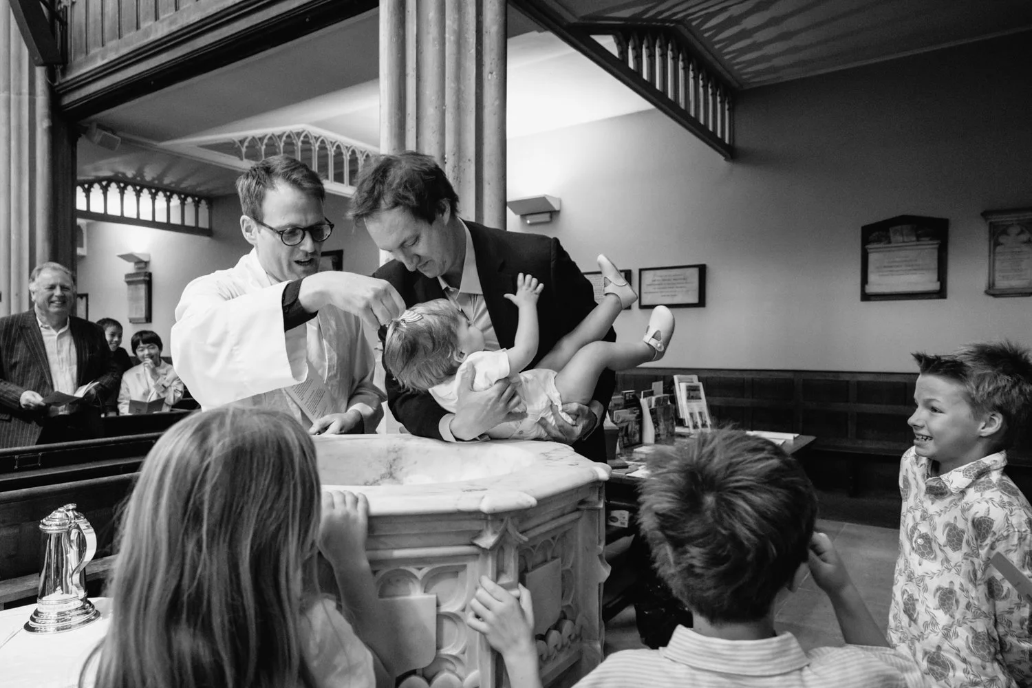 Baby boy has water drizzled over his head at the moment of baptism