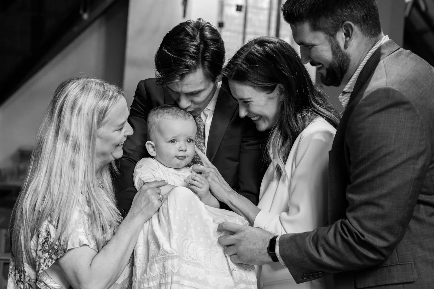 Parents and Godparents surrounding and smiling at the baby.