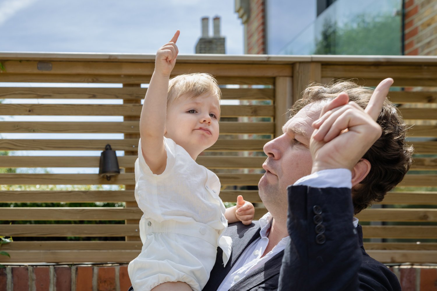 Godparent and godchild both pointing at the sky