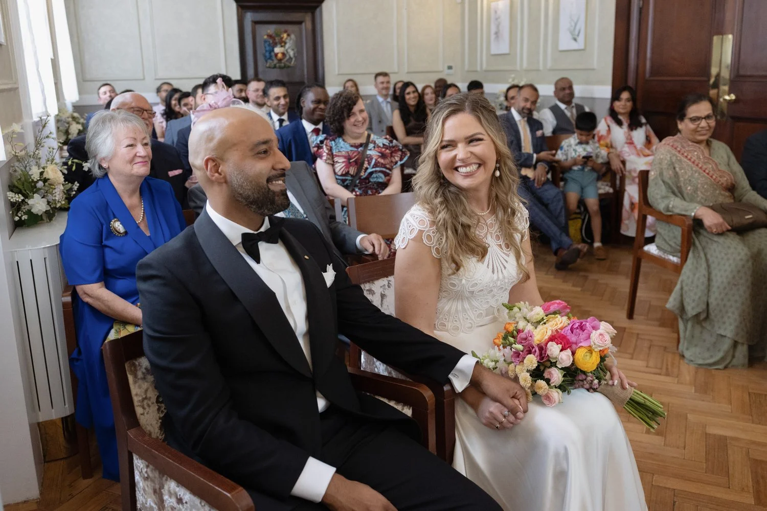 Bride looking adoringly at groom during ceremony as they sit down