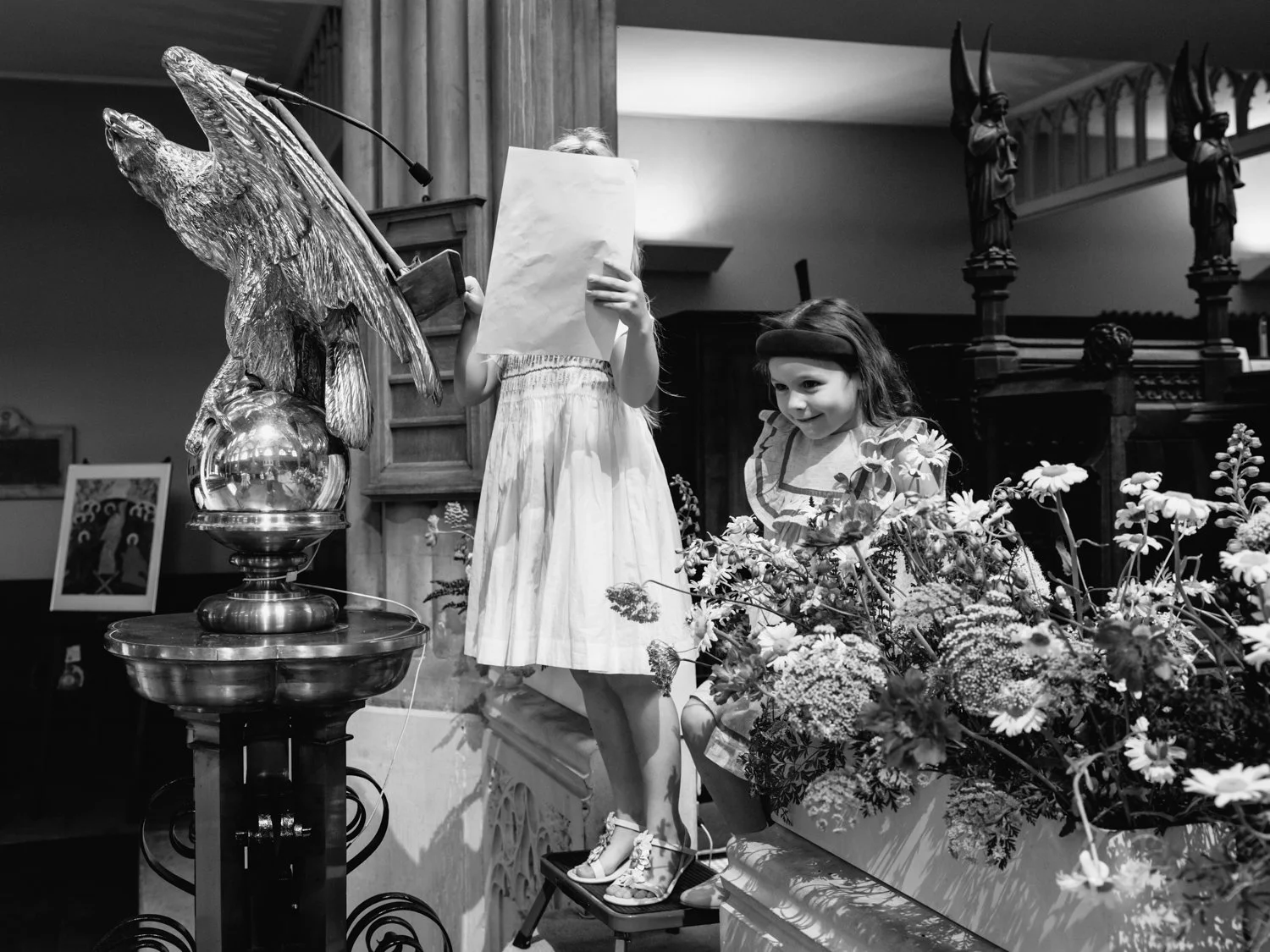 Girl at the pulpit reading with her sheet covering her face.