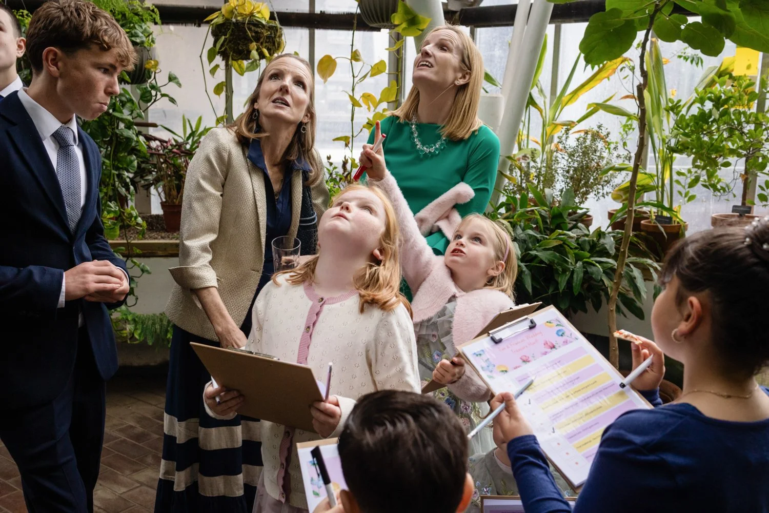 Guests look up at plants in the Conservatory as they work out a fun quiz about their location.