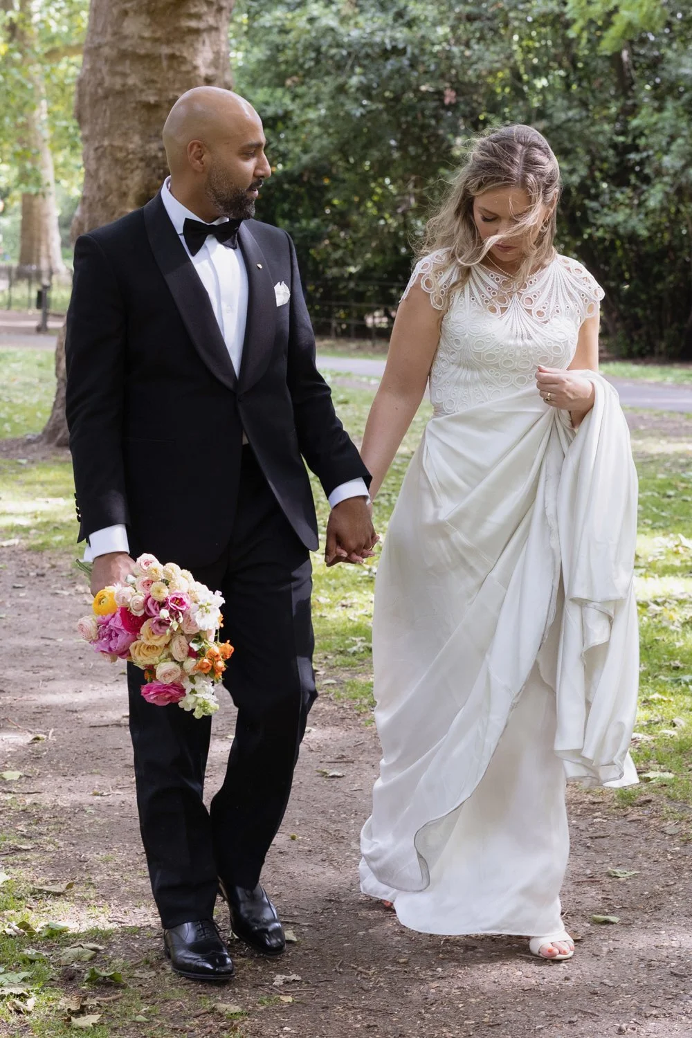 Bride and Groom walking along leafy path