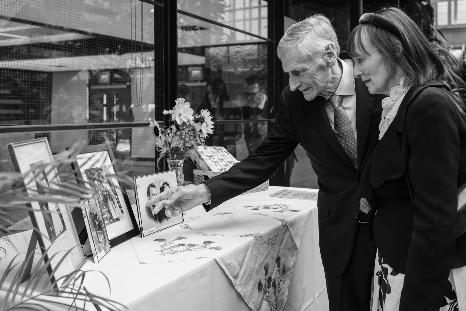 Guests looking at framed images of bride and groom's grandparents and great grandparents.