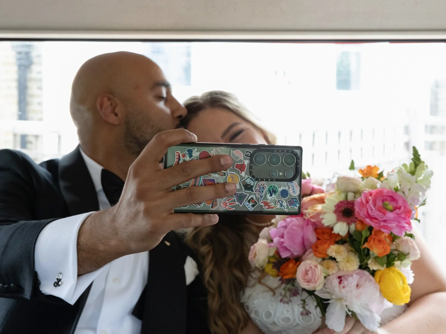 Groom taking a selfie of them together on the bus.