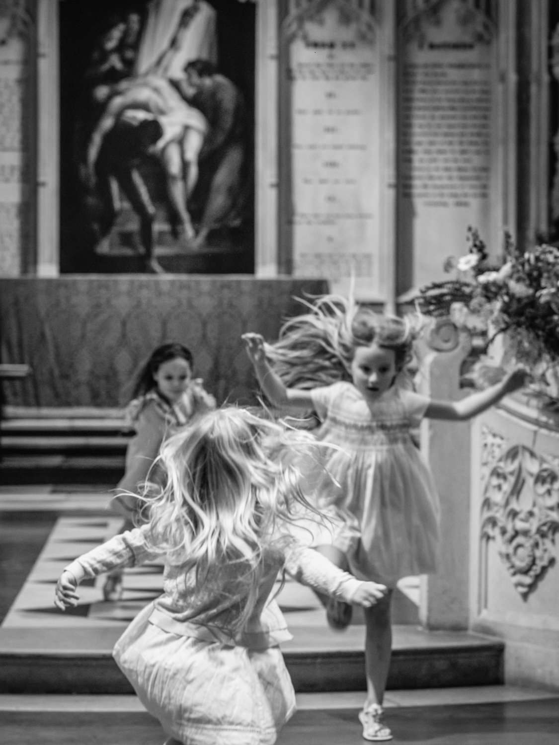 Children with hair flying and running from the altar piece