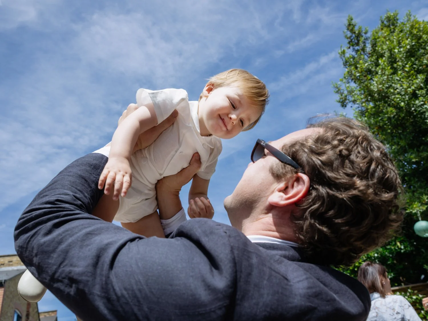 Godfather throwing delighted godson into the air