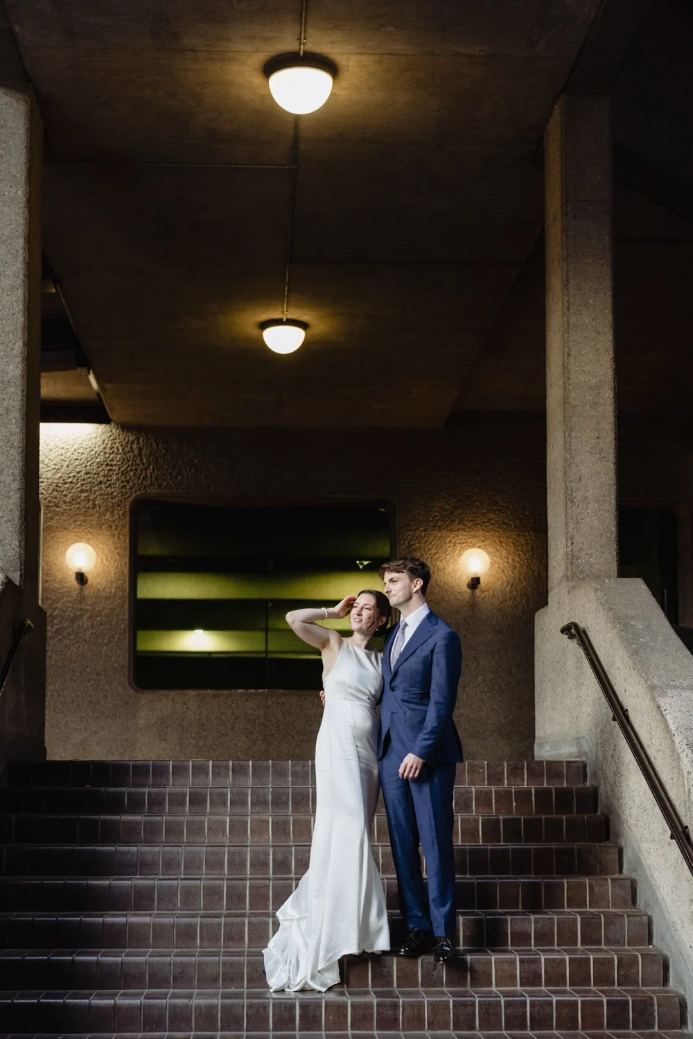 Bride and Groom look out with shaft of light hitting them.