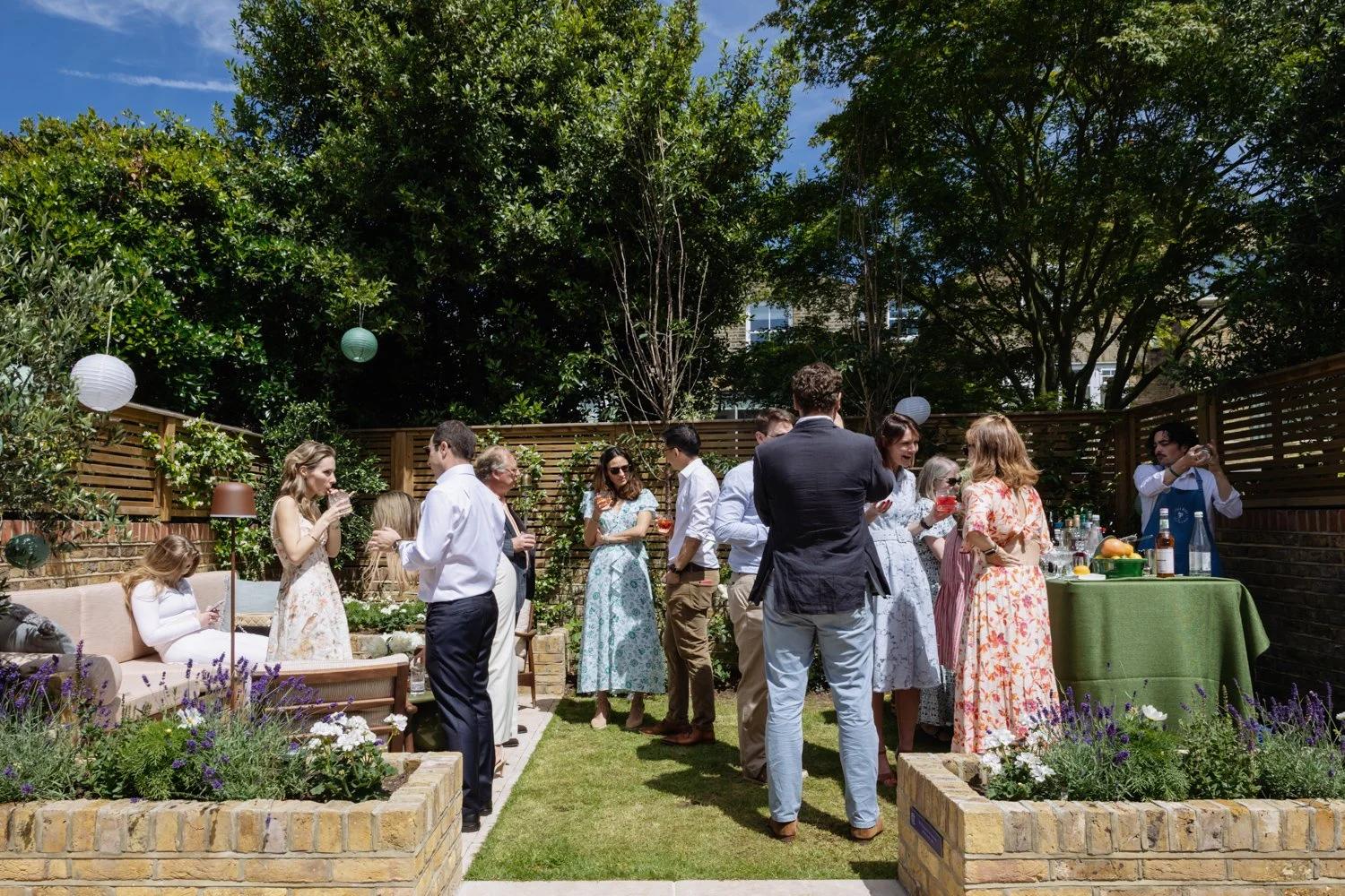 Guests gather for drinks in the garden for the christening reception.