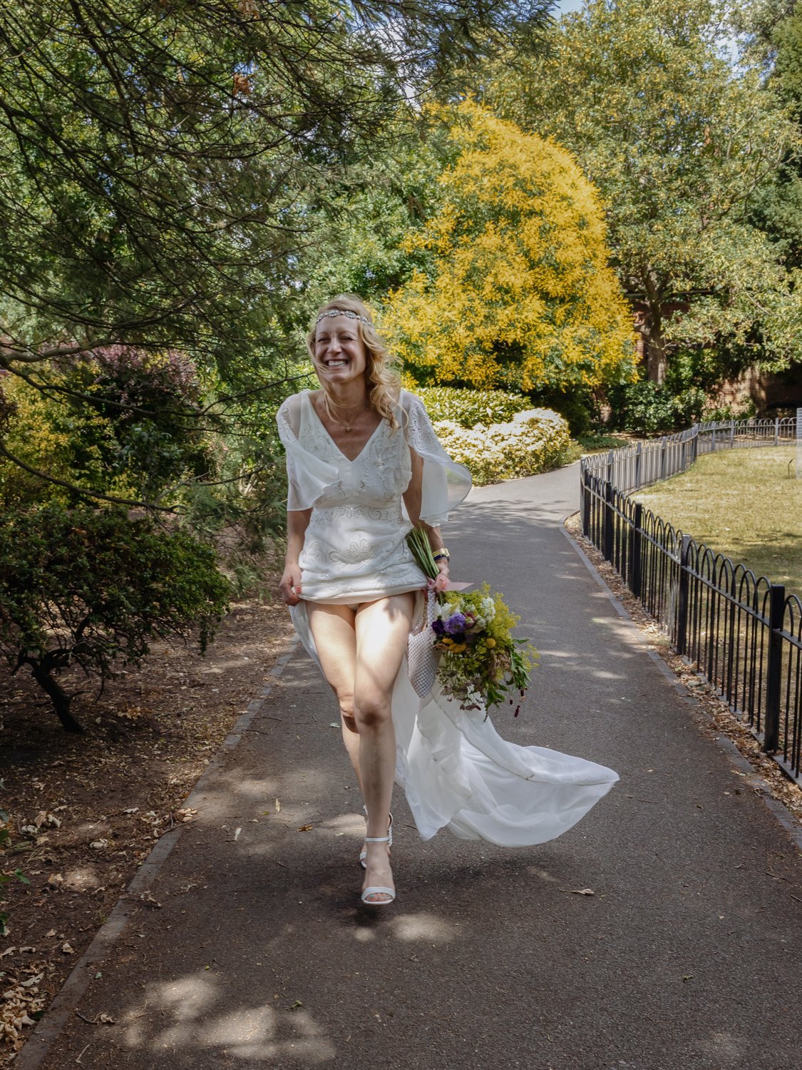 A bride late for her wedding hitches up her dress to run to registry office.