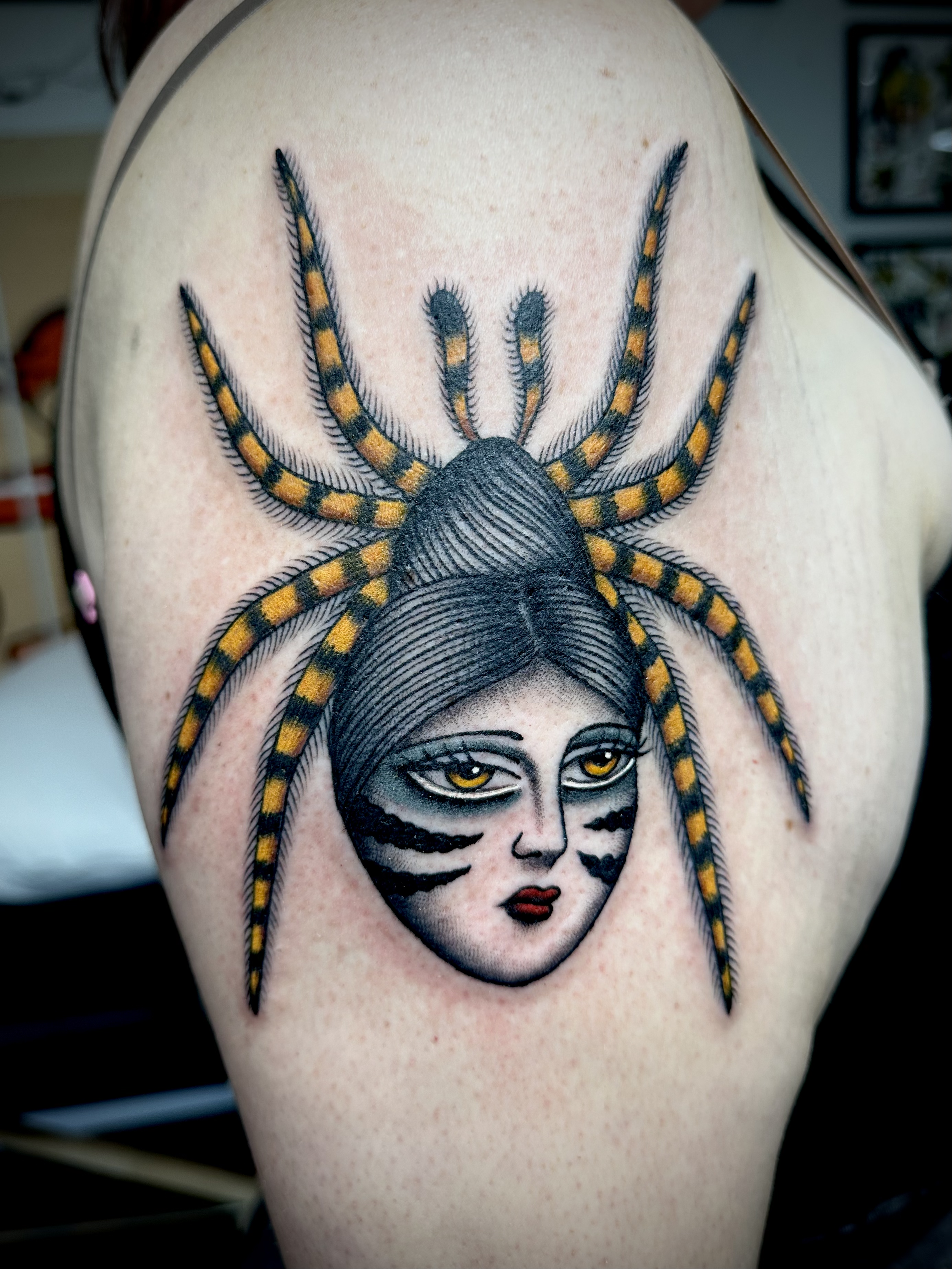 Spider tattoo with woman's face in body.