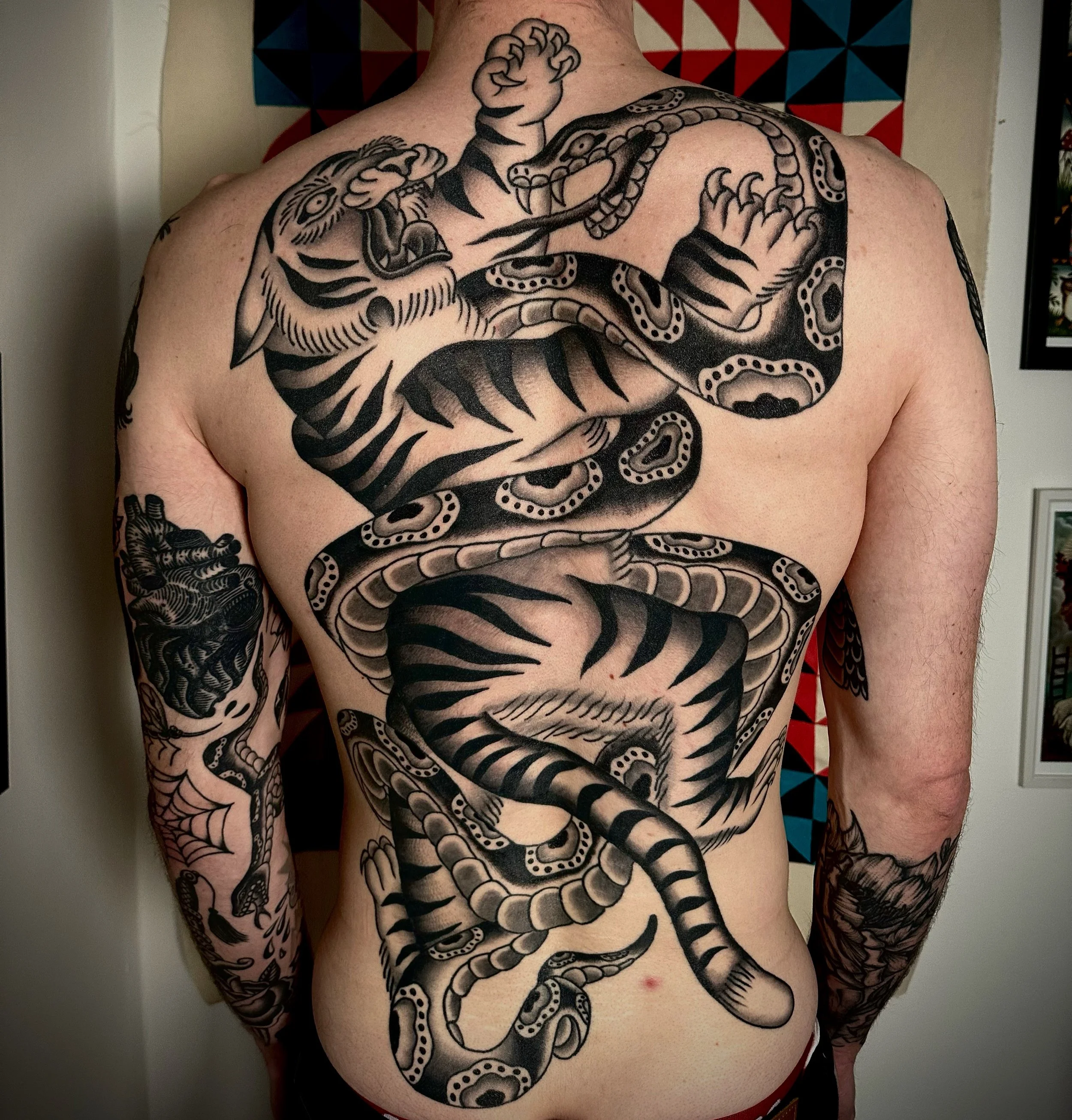 Back piece tattoo of snake and tiger.