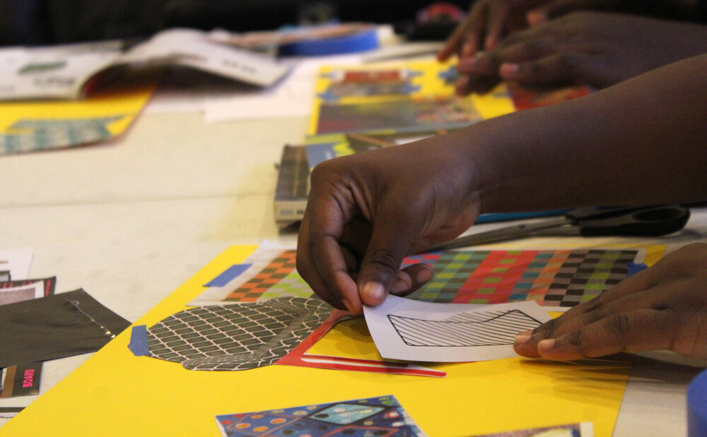  Hands assembling a collage of cut paper. Credit: Mae Morris 