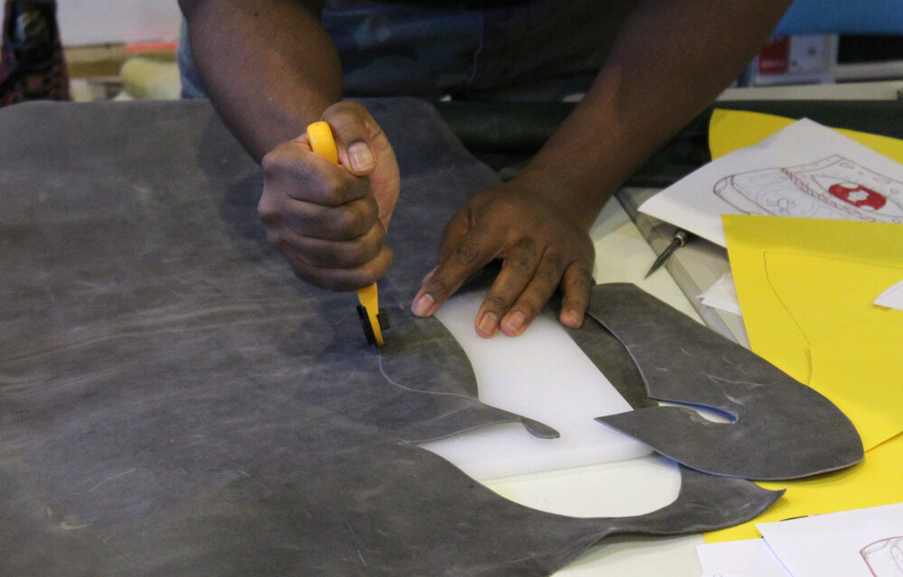  Person cutting out leather shape with a rolling blade. Credit: Mae Morris 