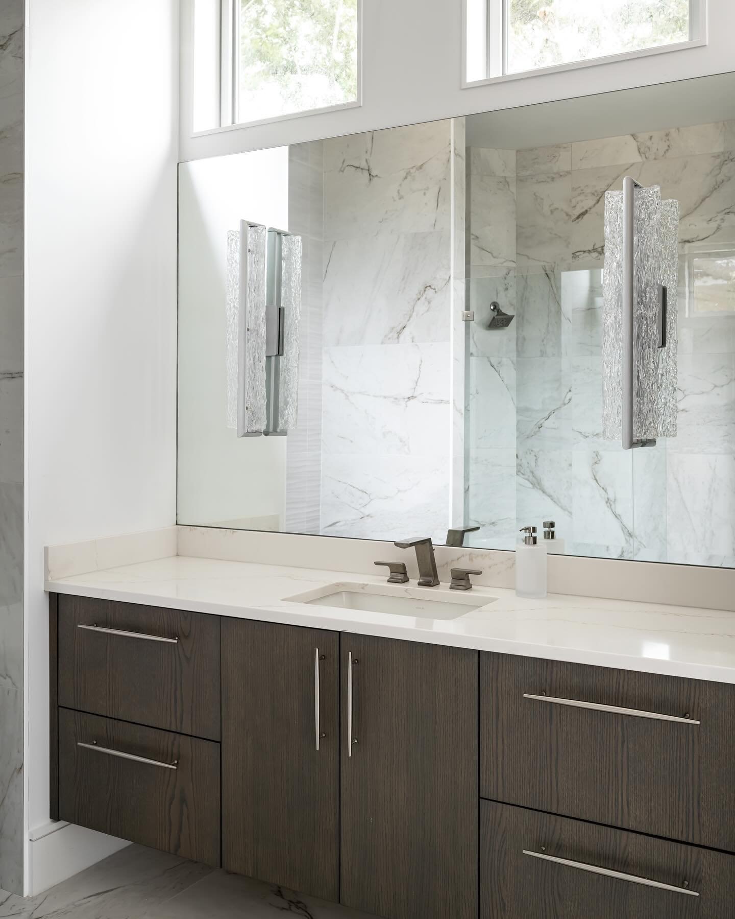 The Primary Bathroom boasts an exquisite and sophisticated design that exudes cleanliness and brightness. The addition of sconce lighting brings a touch of elegance and refinement, contributing to the overall ambience.

Project: By The Bay
Designer: 