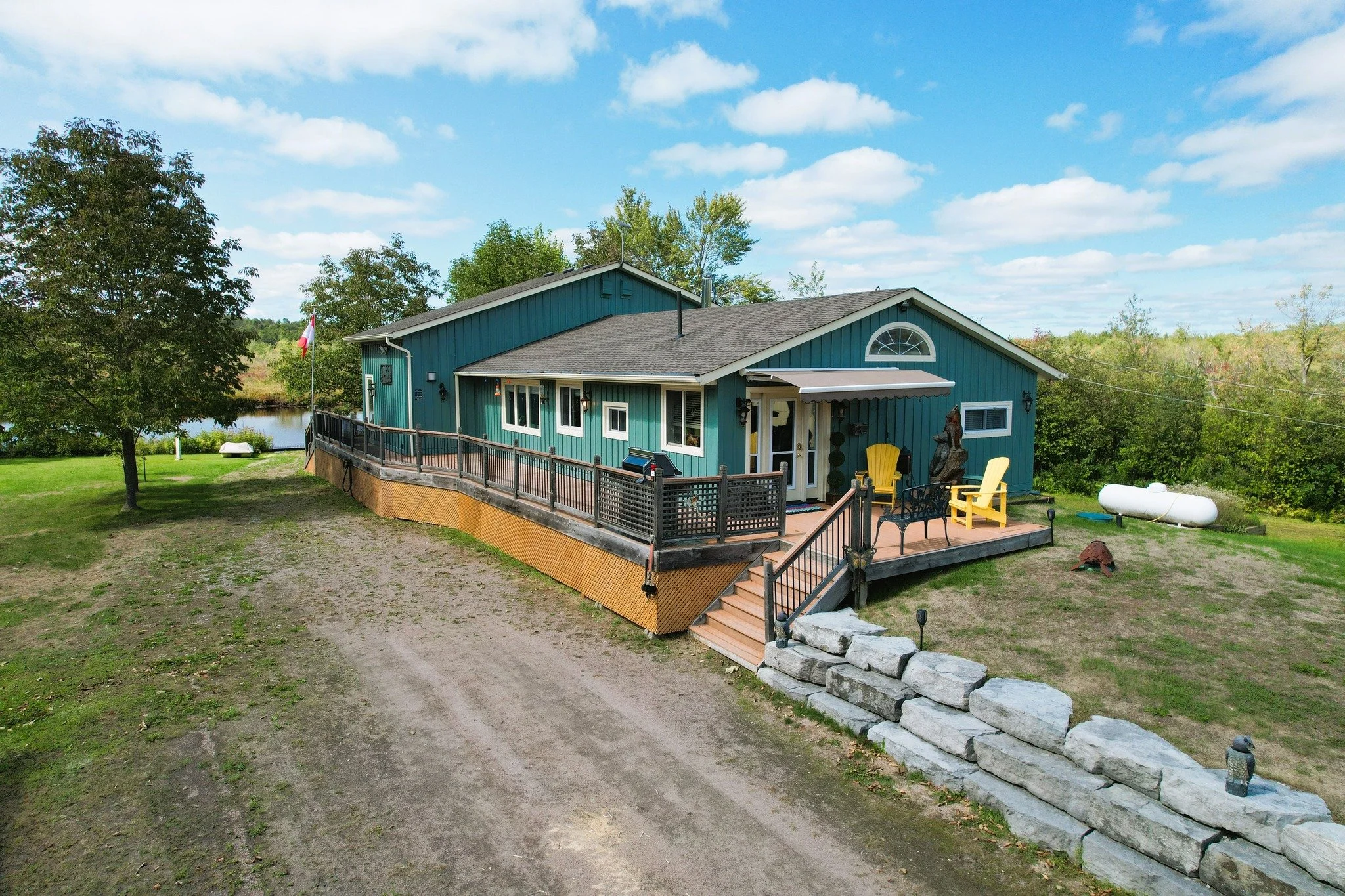 Experience the tranquility & privacy of this unique rural property, nestled at the foot of Head River off of picturesque Head Lake. Welcome to 195 North Shore Road!
A spacious Great Room features soaring ceilings and a spectacular antler chandel