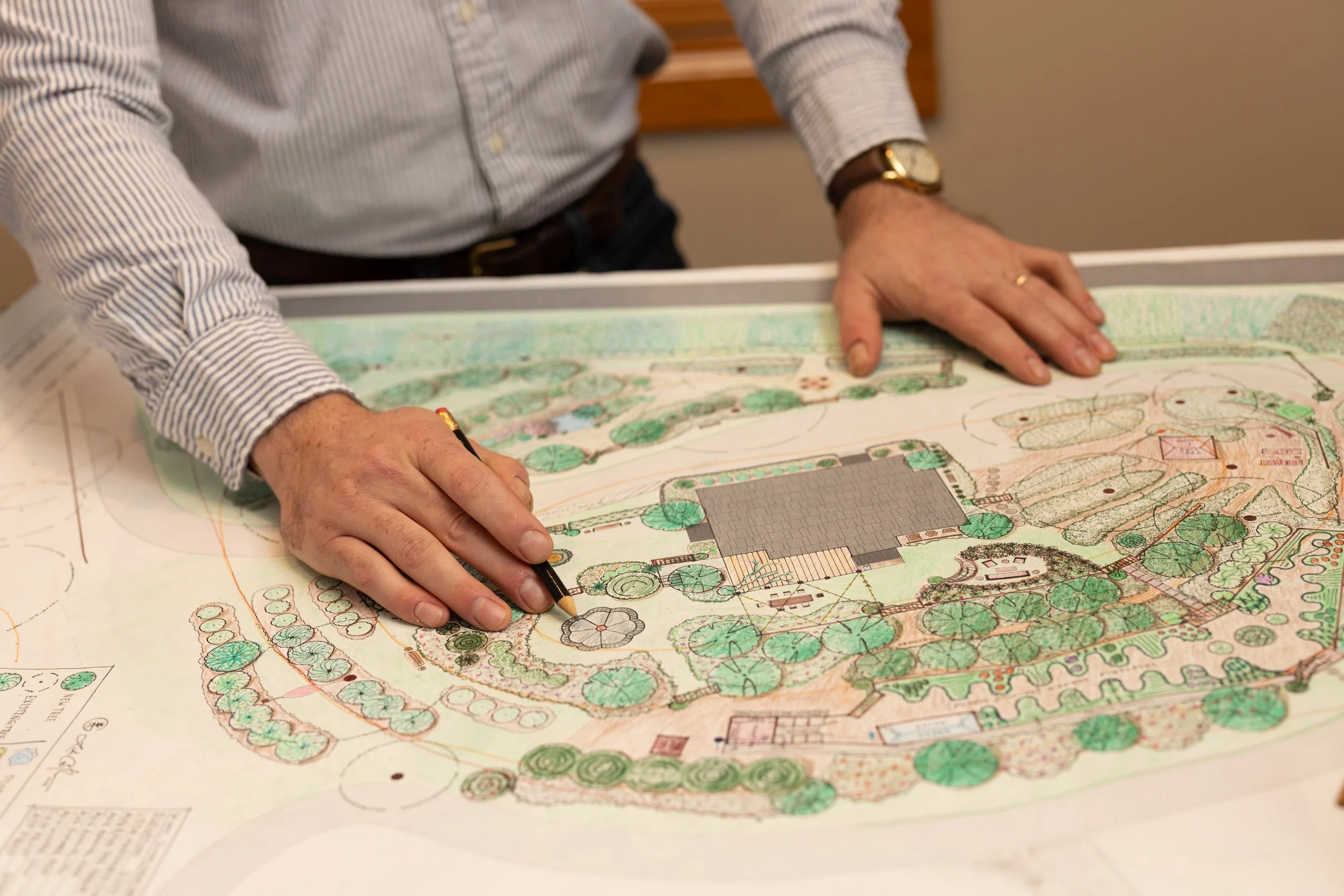 Luke Costlow reviewing a hand-drawn permaculture design plan for a residential landscape