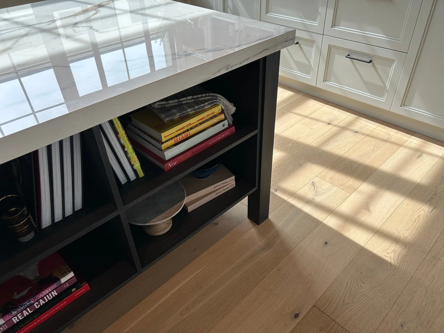 A recent visit to a kitchen cabinetry showroom.⁠
⁠
One detail we kept coming back to was an island with open storage for cookbooks and everyday pieces. We love the idea of incorporating spaces that are both functional and personal&mdash;keeping favor