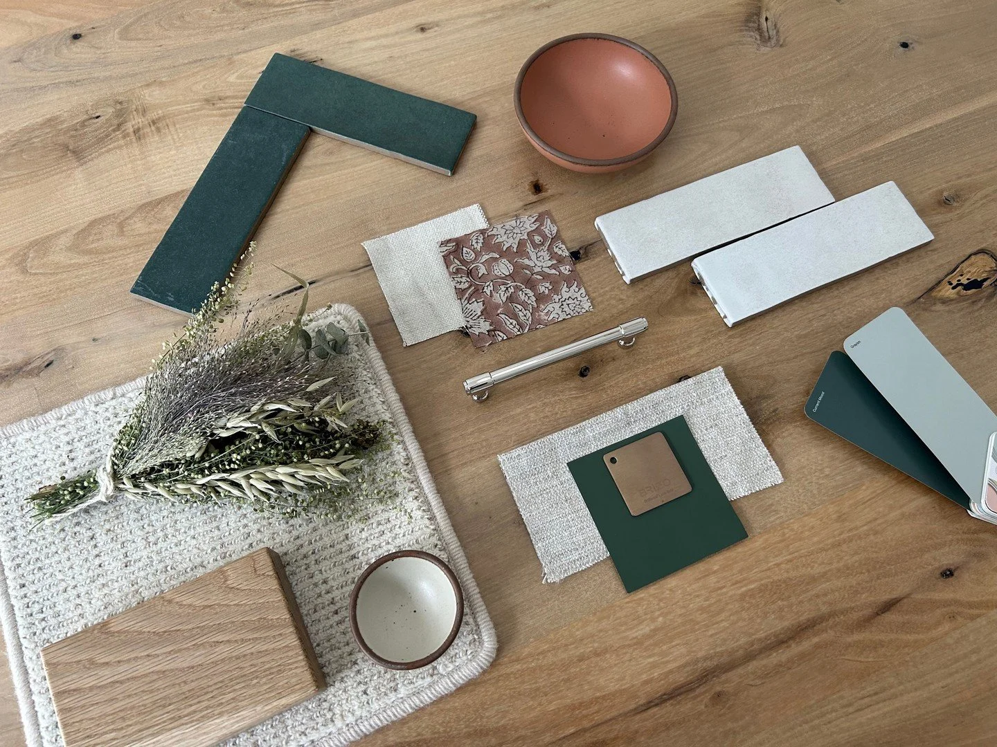 We&rsquo;re drawn to materials that feel timeless, tactile, and connected to place. The softly varied wall tile introduces subtle movement, while the deep green shower tile references the wooded landscape surrounding the home. Together with warm oak 
