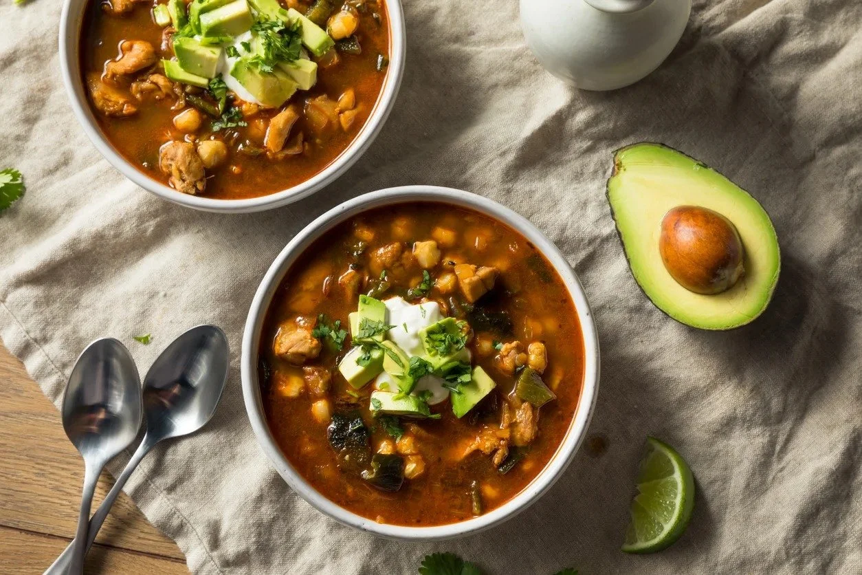 Chicken tortilla soup topped with avocado, sour cream and cilantro