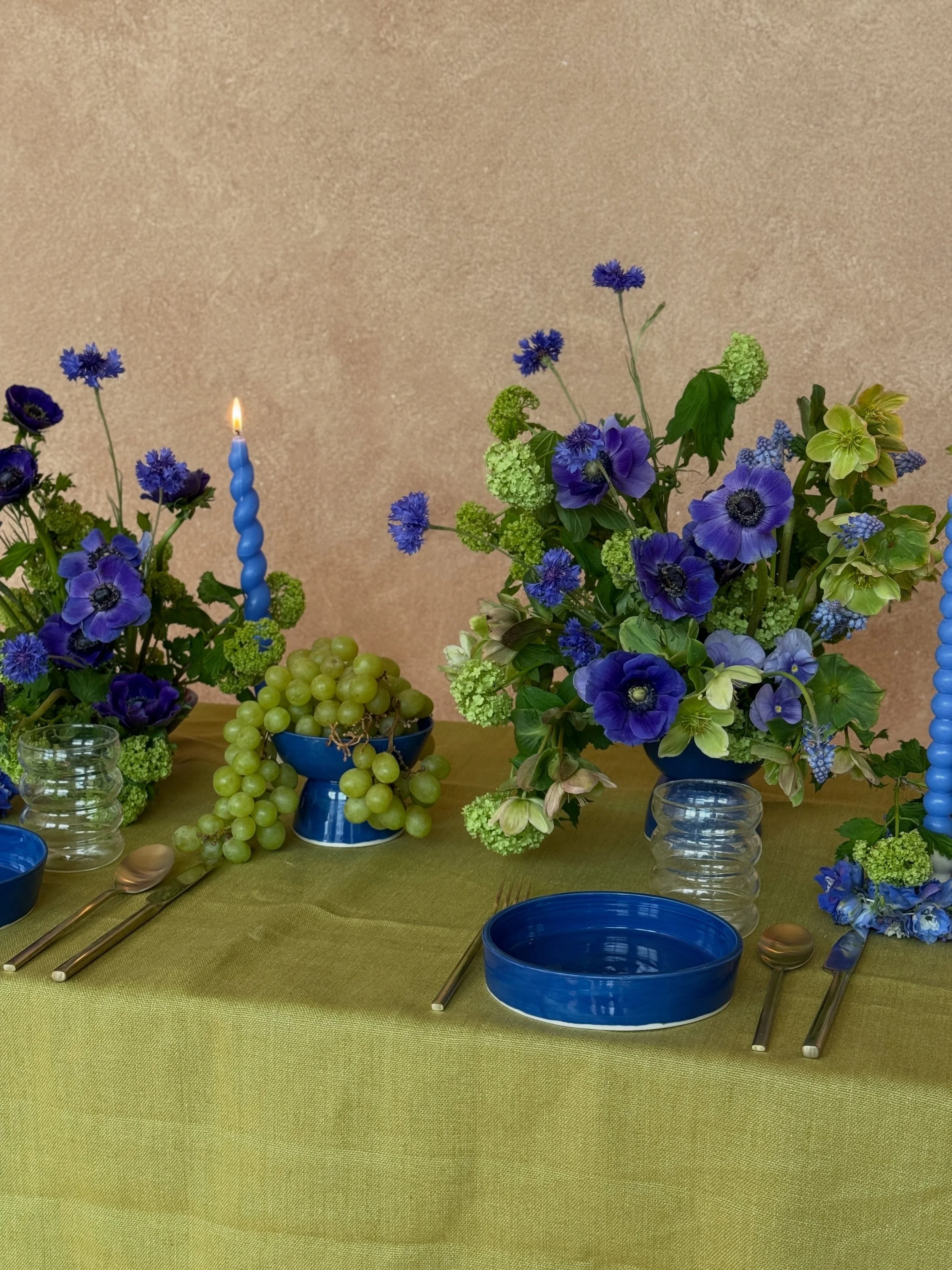 A tablescape of green and blue flowers, fruit, and cobalt blue decor! Part Two from my April shoot included a tablescape using vases and bowls I handmade. I enjoyed seeing this vision come to life starting with these blue bowls 💙 Swipe through to se