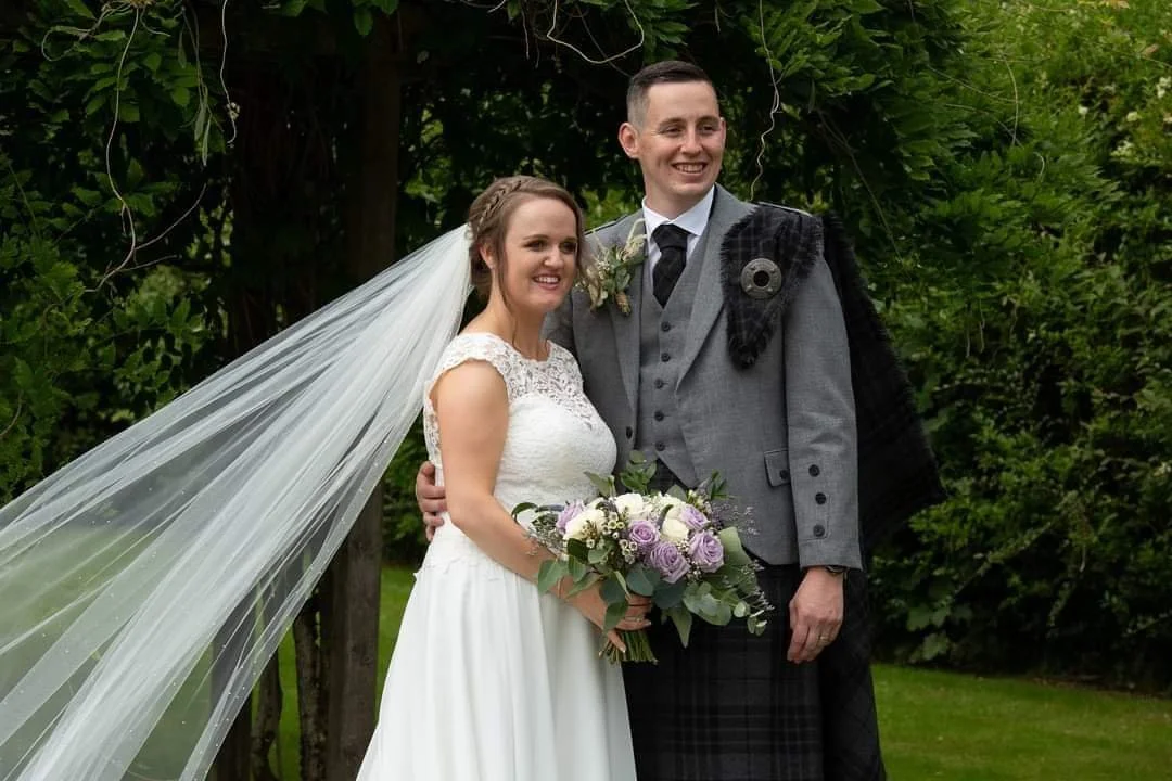 bride and groom with lilac wedding bouquet