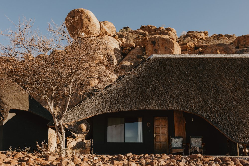 Thatch roof chalet between rock formations