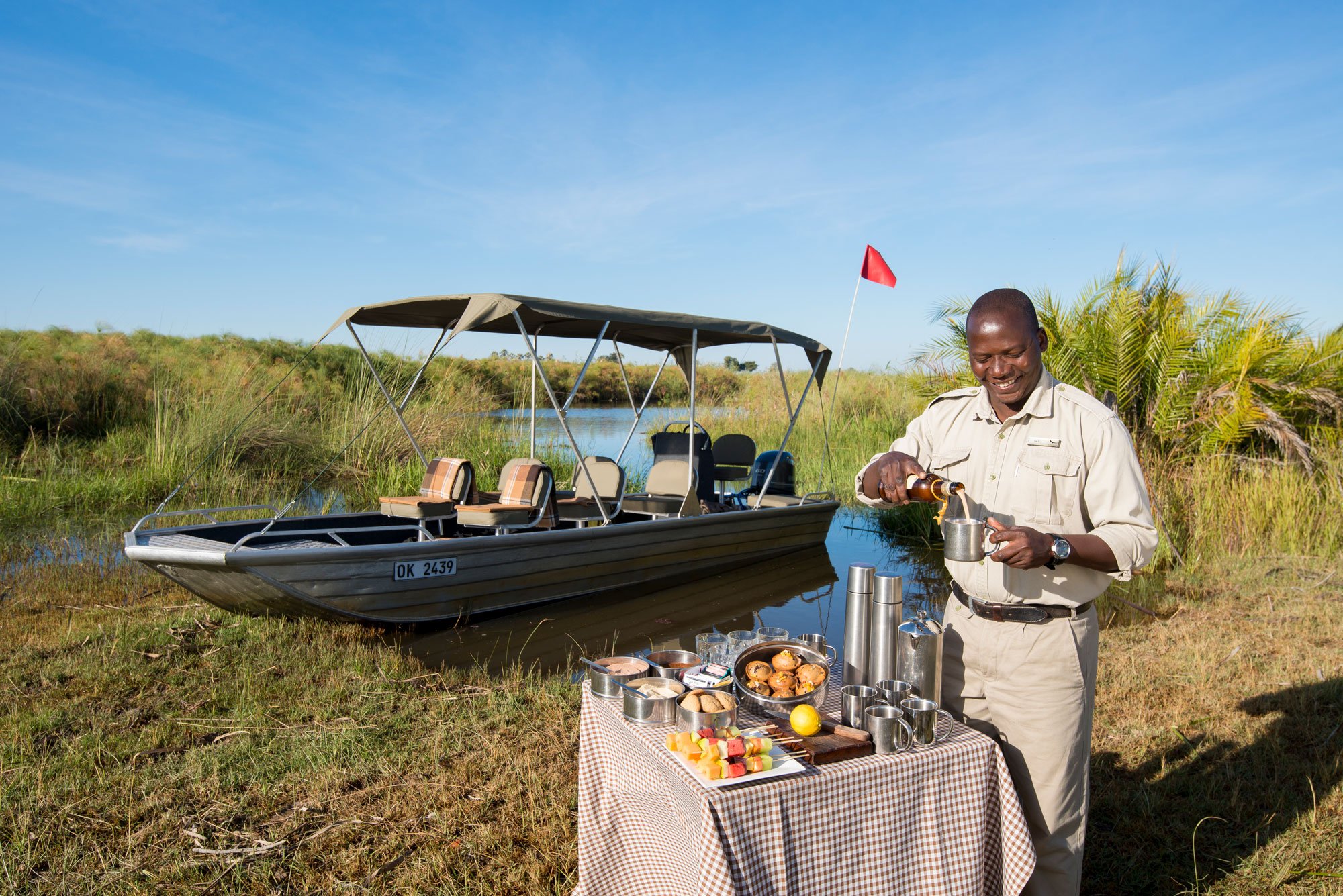 Botswana-Nxabega-Okavango-Tented-Camp-Guest-Delight-butler-setting-up-drinks-after-boat-ride.jpg