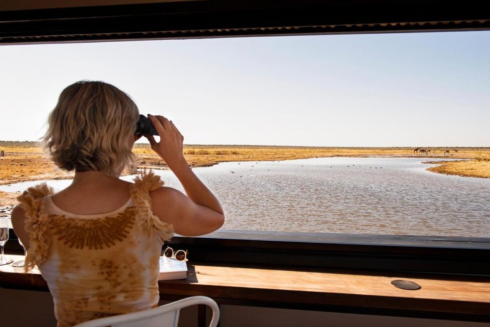 Woman viewing wildlife at Etosha King Nehale, Namibia