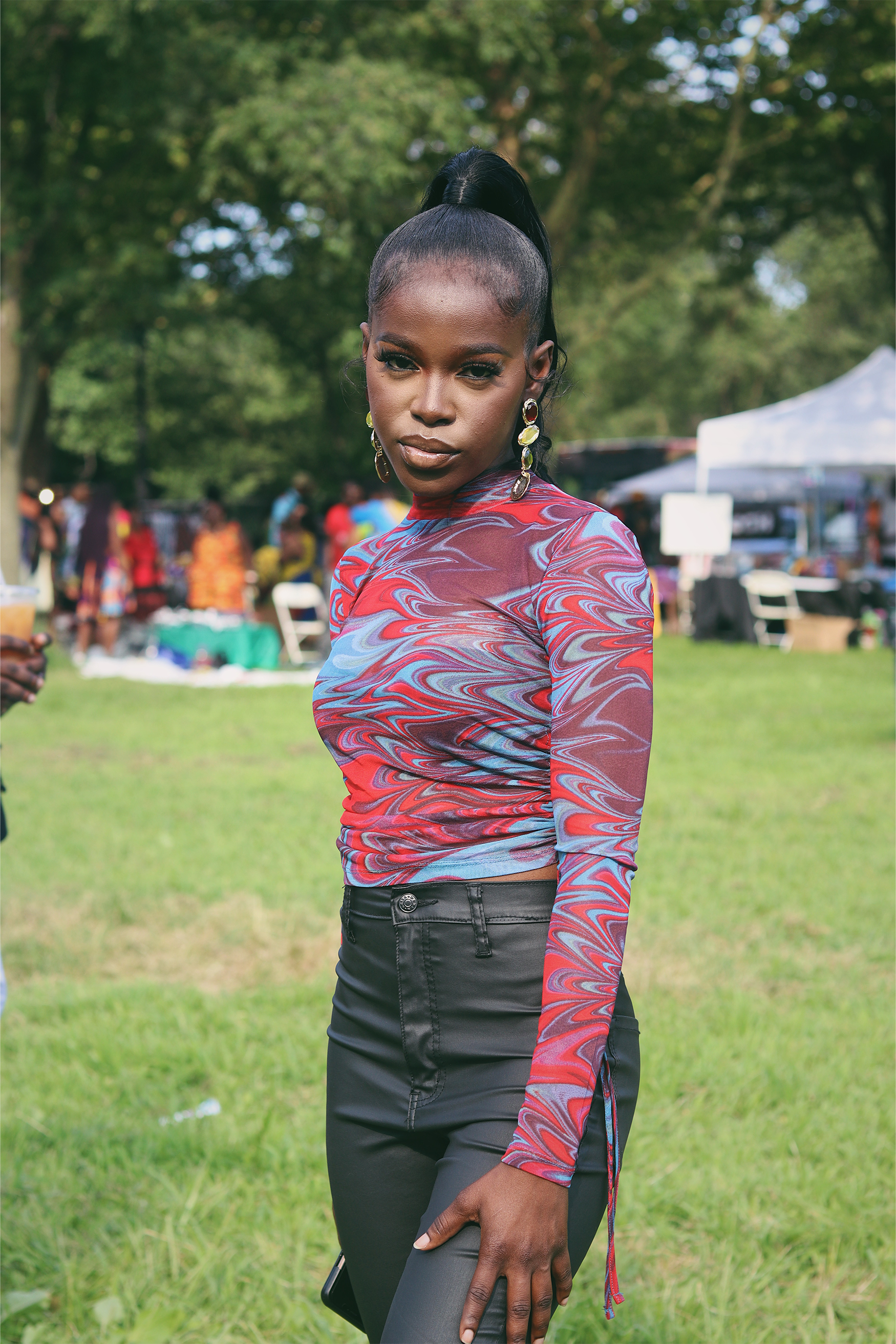 Queen Drie in leather pants and sheer standing on Washington Park, Chicago