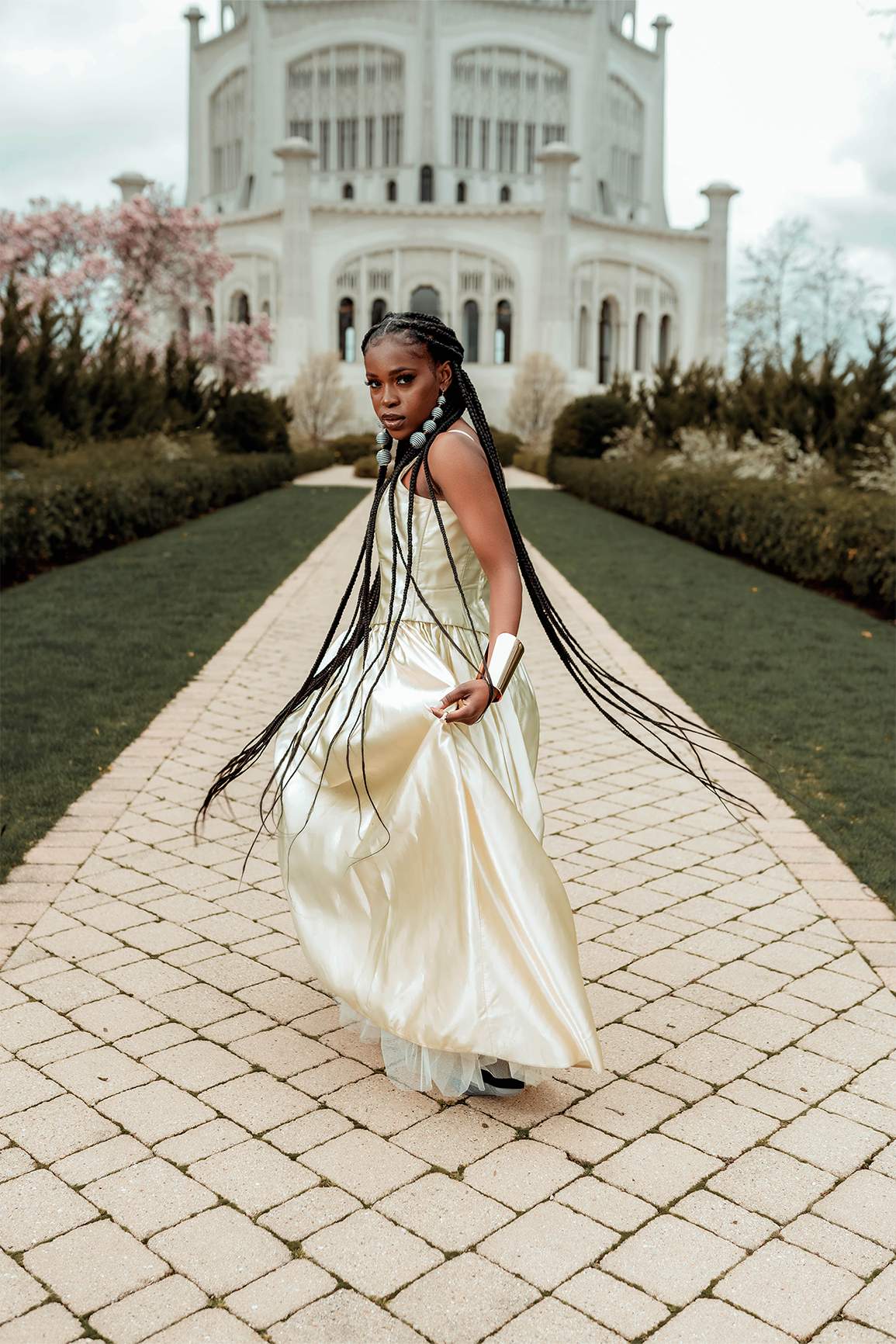 Queen Drie in a royal gown and a gold arm cuff, running at the Bahai House of Worship in May 2022
