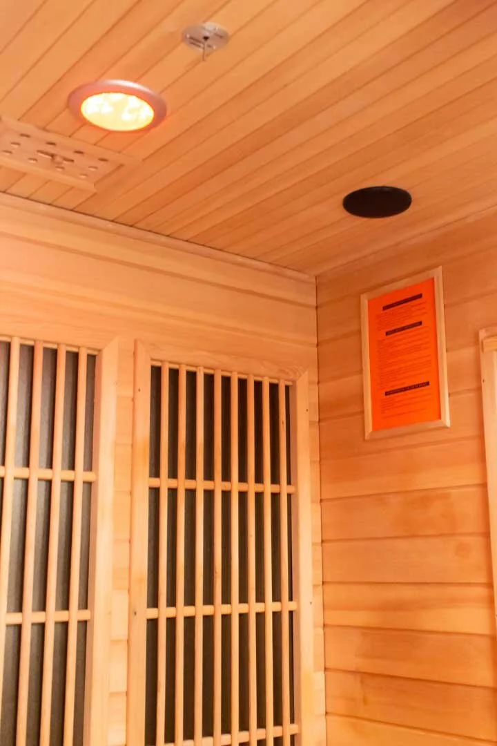 Wood-paneled ceiling with two circular vents and a framed orange poster on the wall.